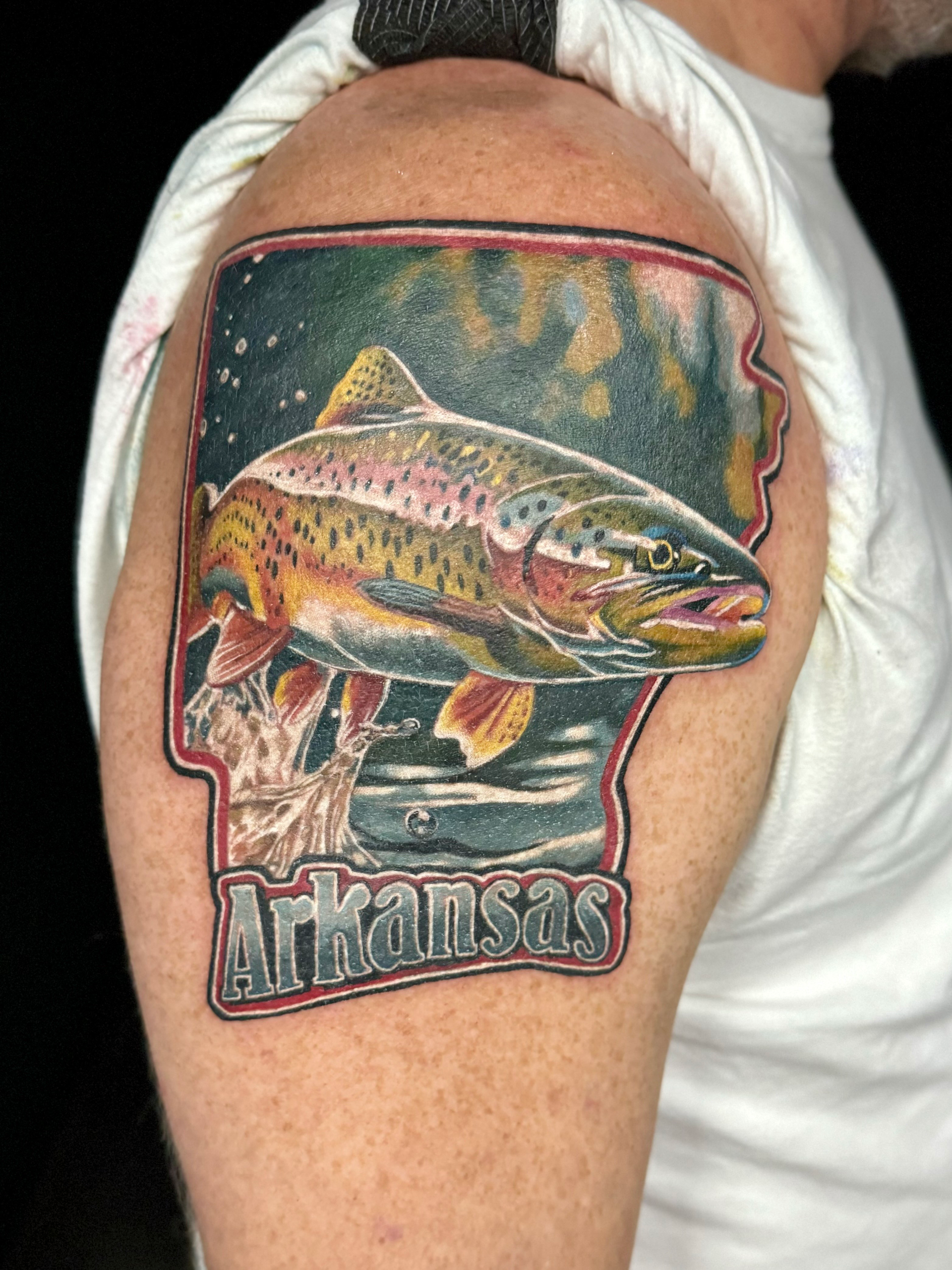 A man has an arkansas tattoo on his arm