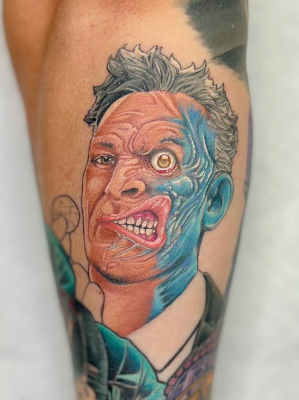 A tattoo of a man with two faces on his leg