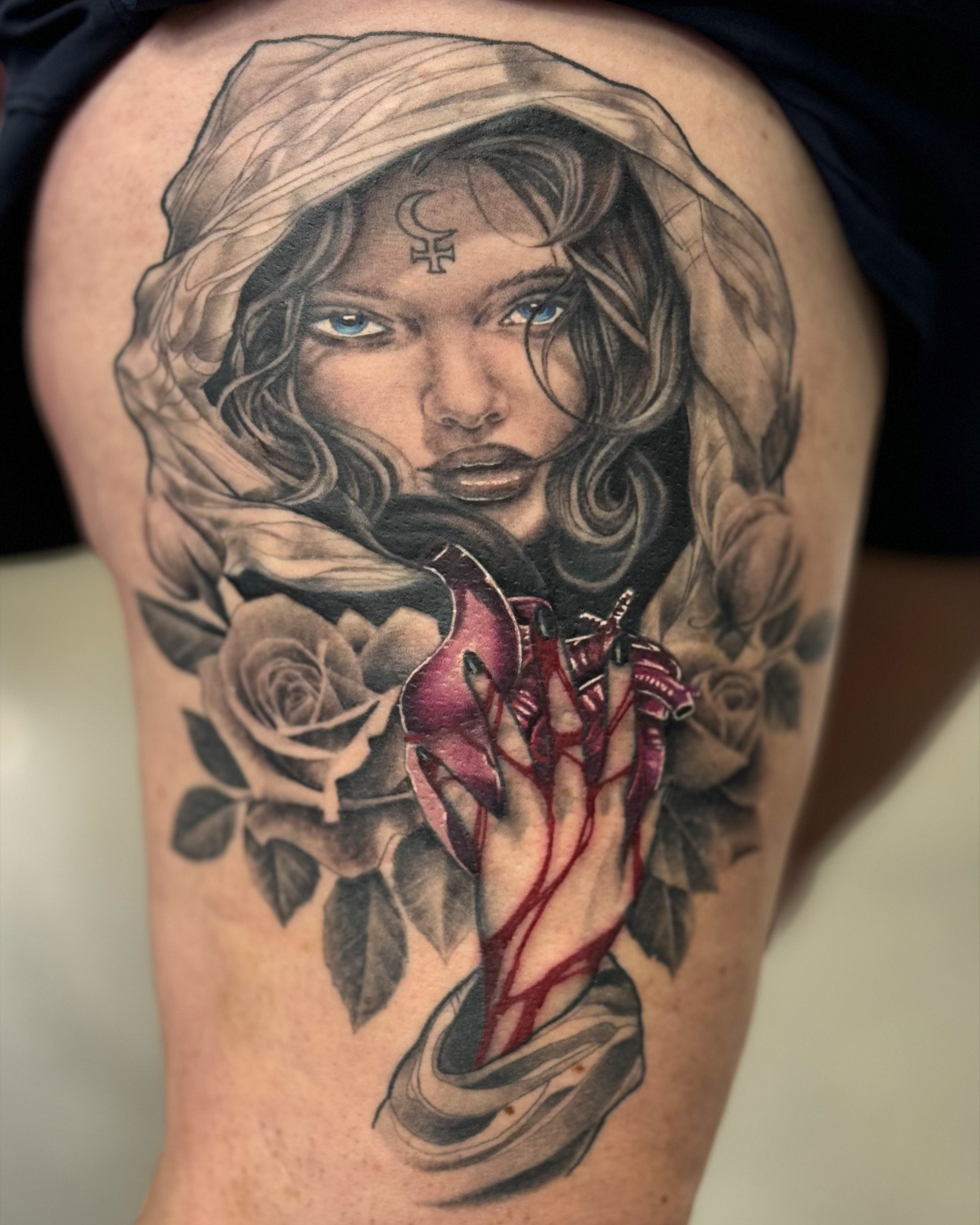 Tattoo of a femail in a black hood with red on her hand