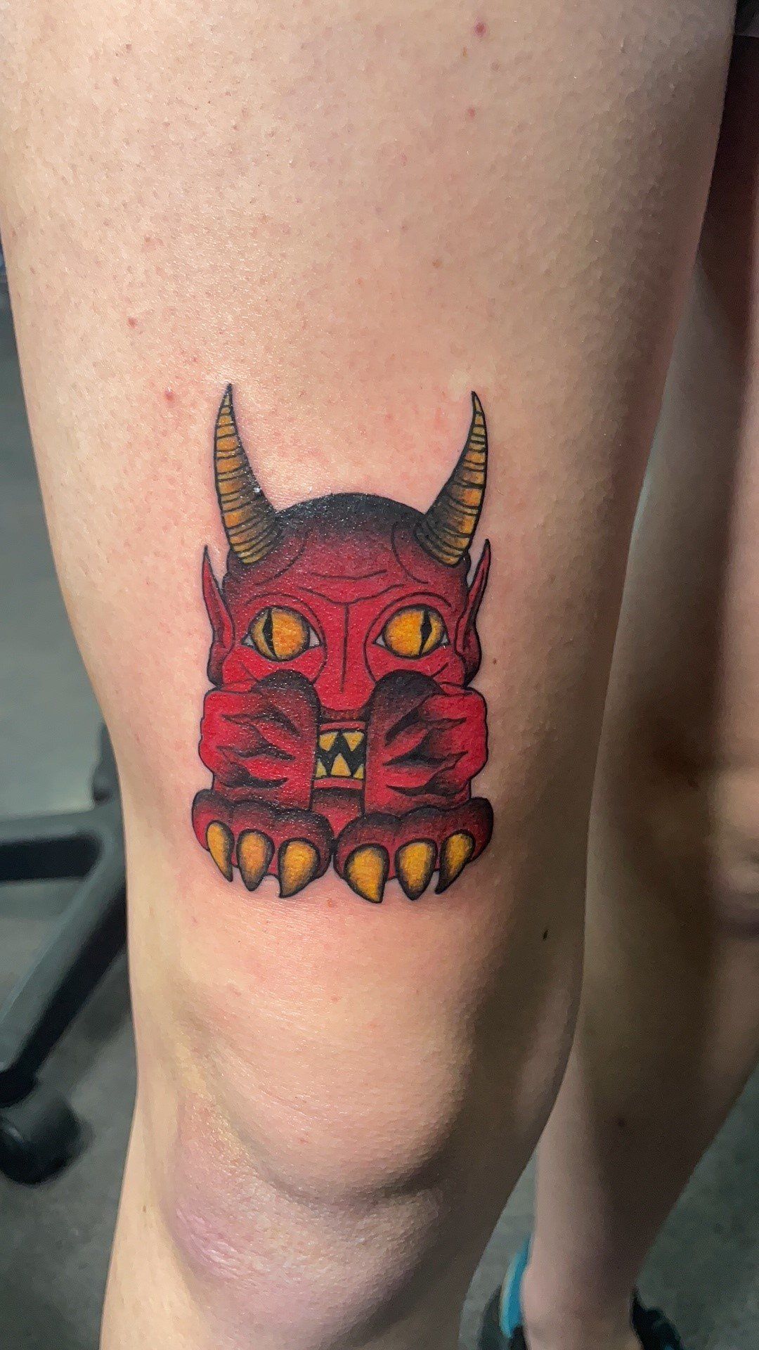 A person has a tattoo of a devil on their knee.