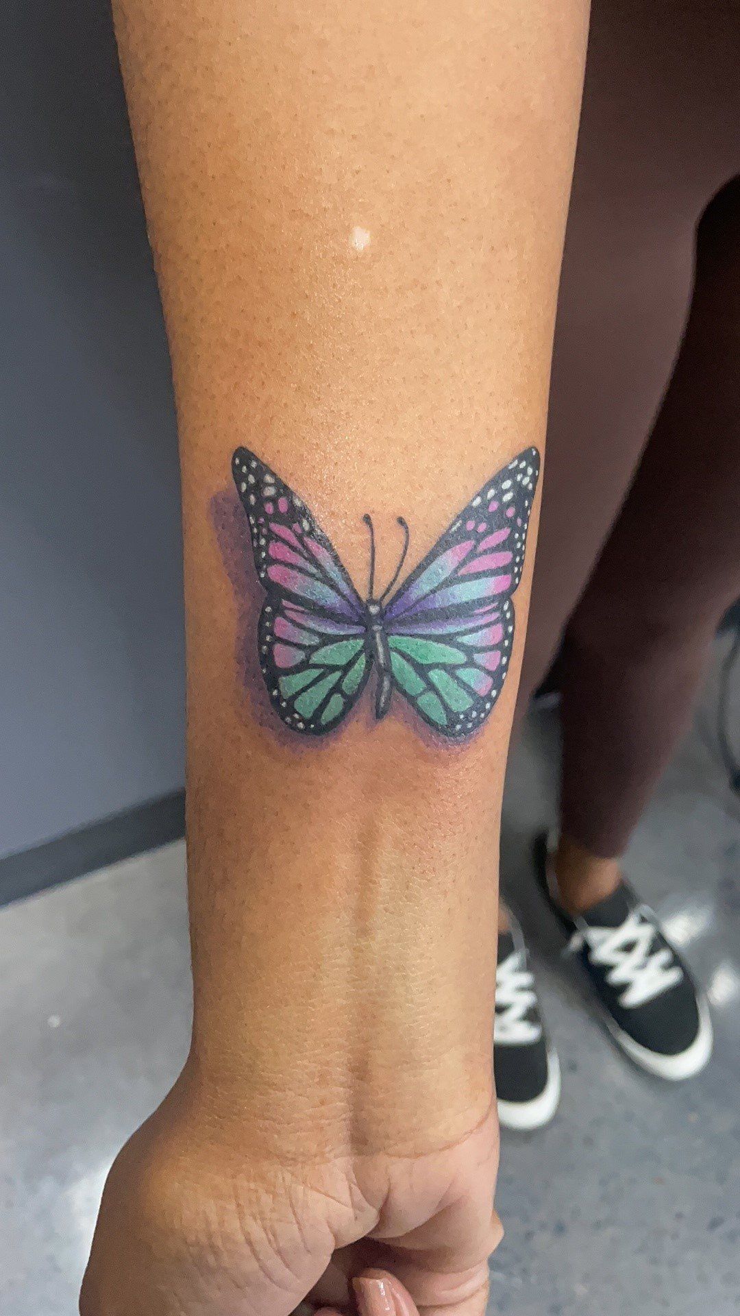 A woman has a butterfly tattoo on her wrist.