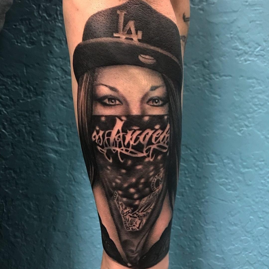 A tattoo of a woman wearing a la hat and a bandana
