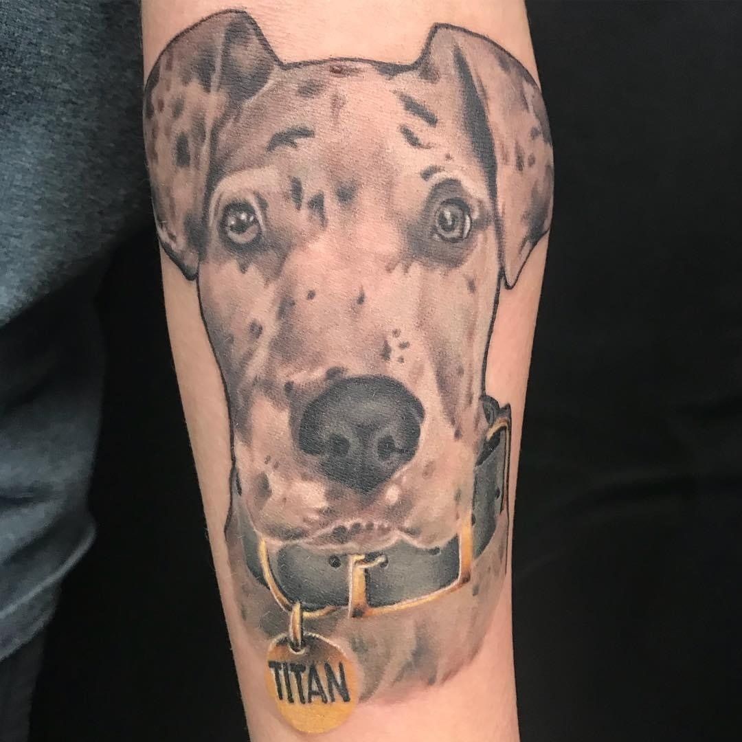 A person has a tattoo of a dog on their arm.