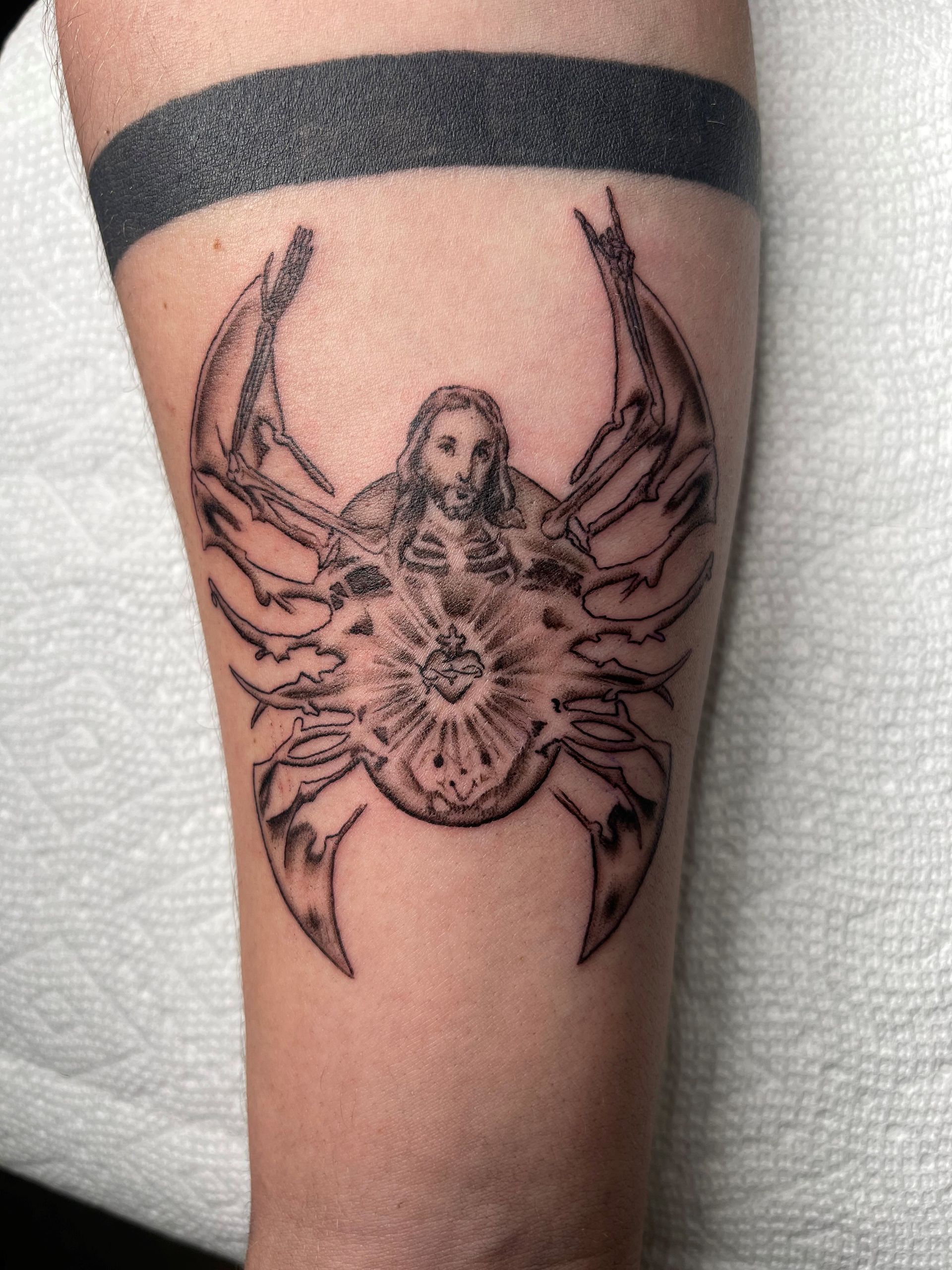 A black and white tattoo of a crab with jesus on it