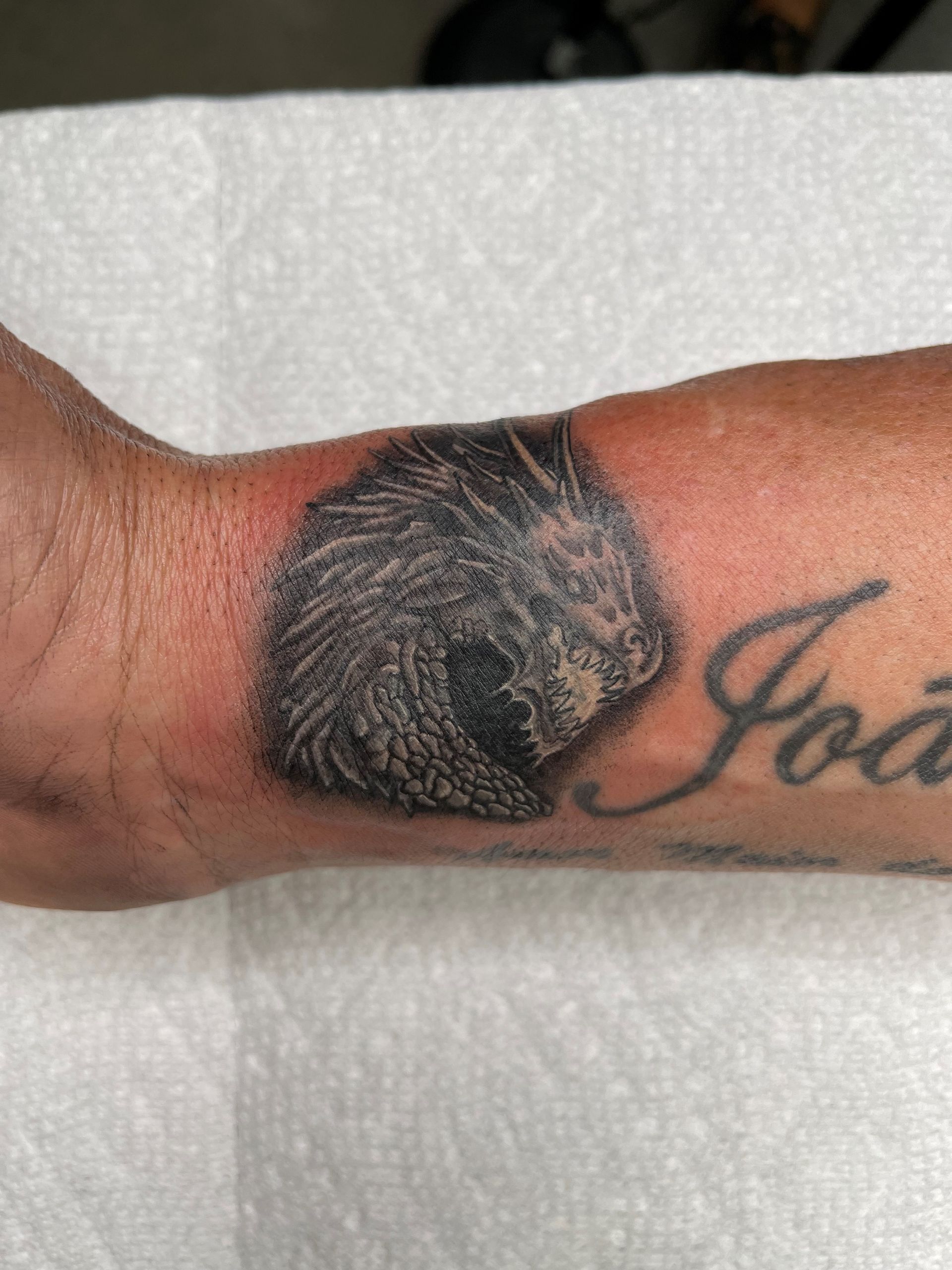 A person has a tattoo of a cat on their arm.