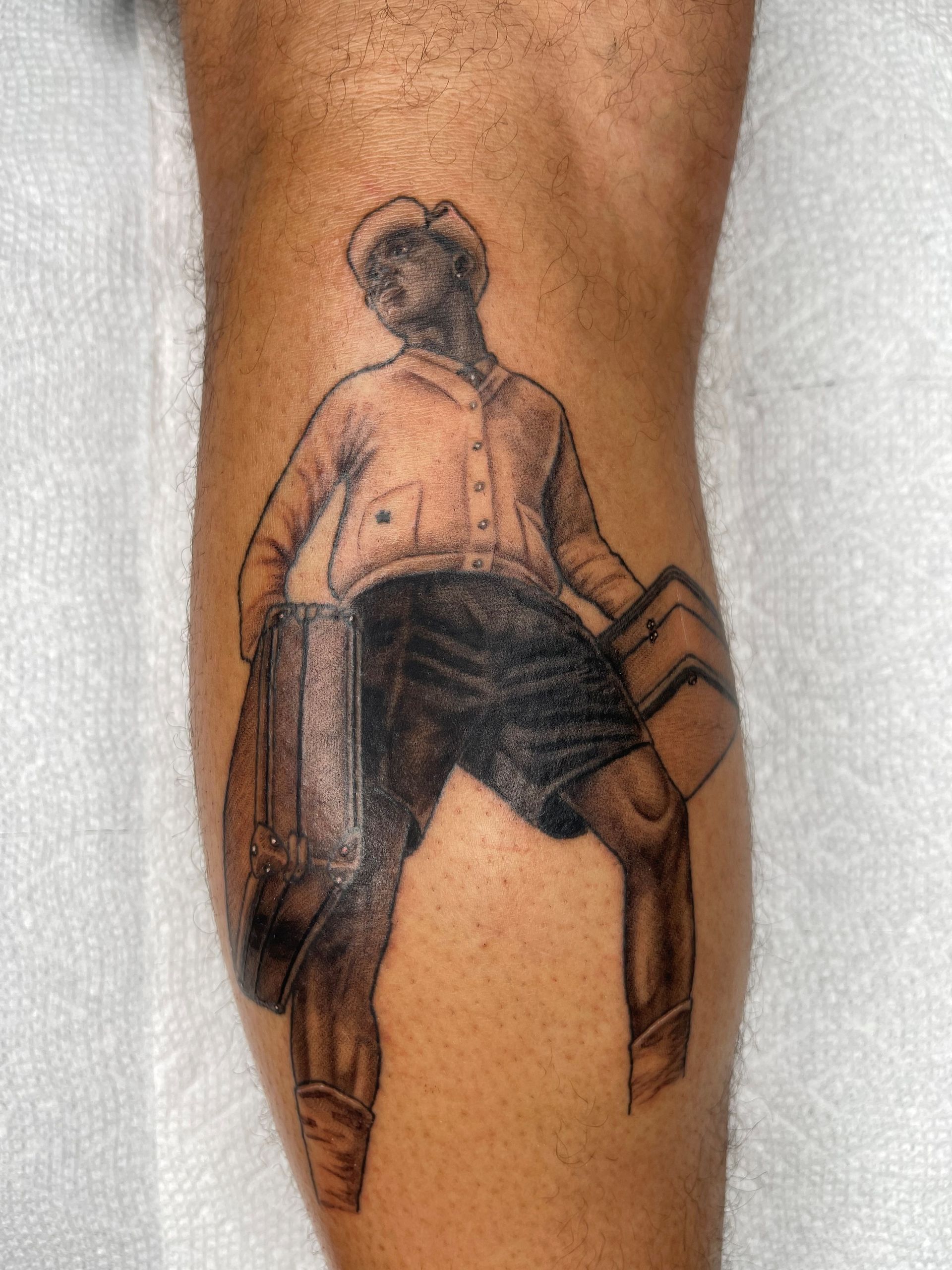 A man has a tattoo of a cowboy on his leg