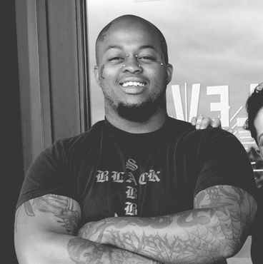 A man wearing a black shirt with the word black on it