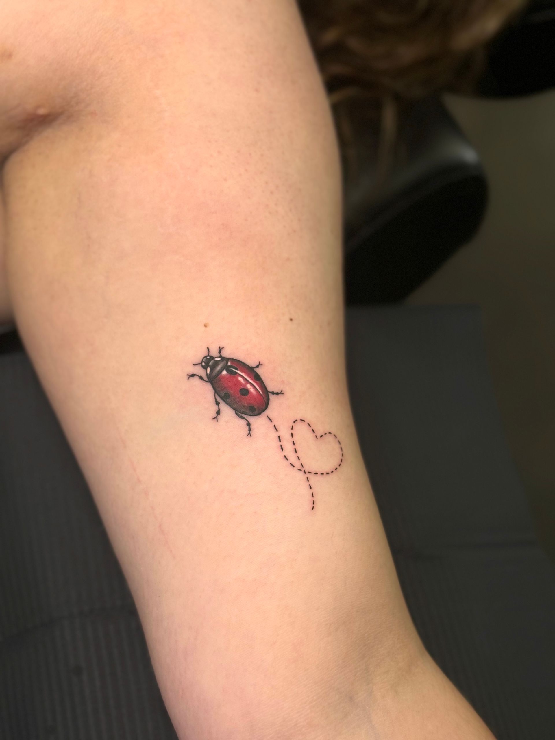 A ladybug tattoo on a person 's arm
