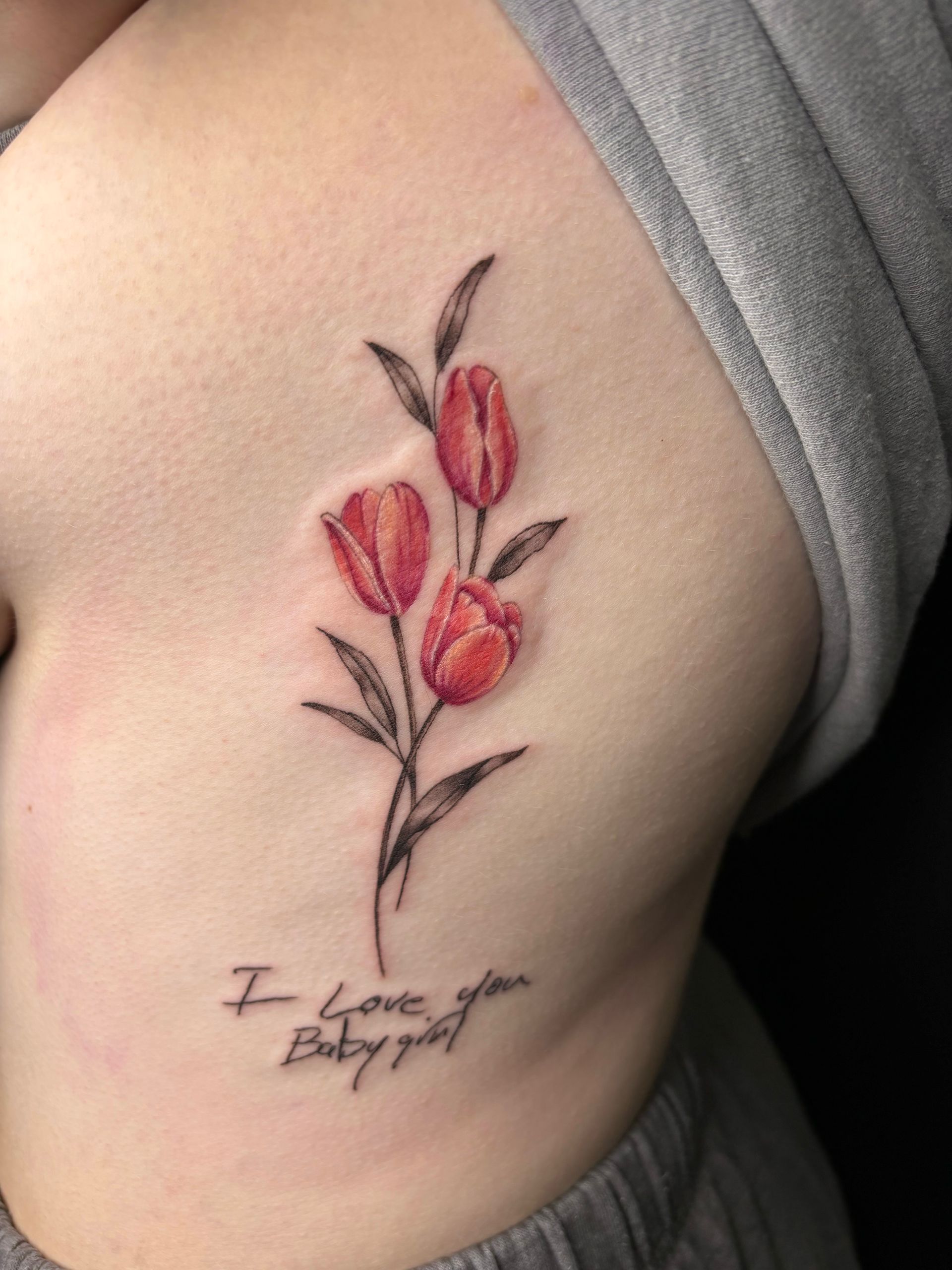 A woman has a tattoo on her side that says i love you baby girl