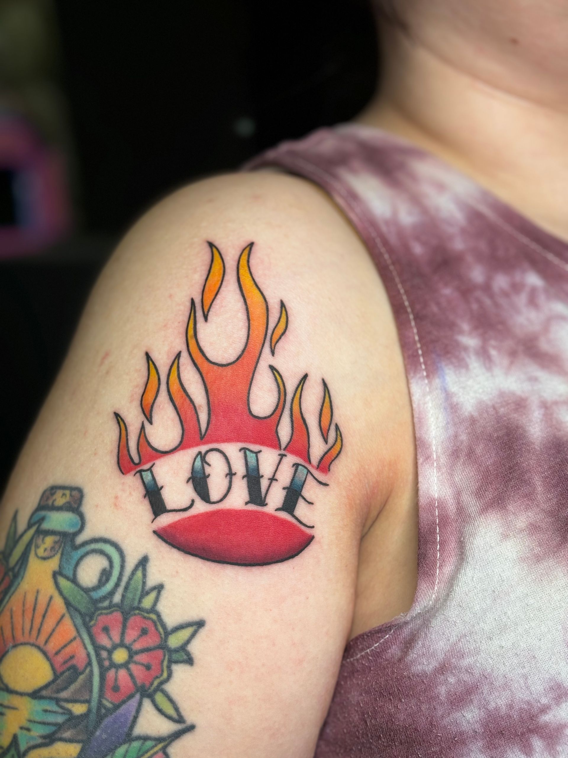 A woman has a tattoo on her arm that says love