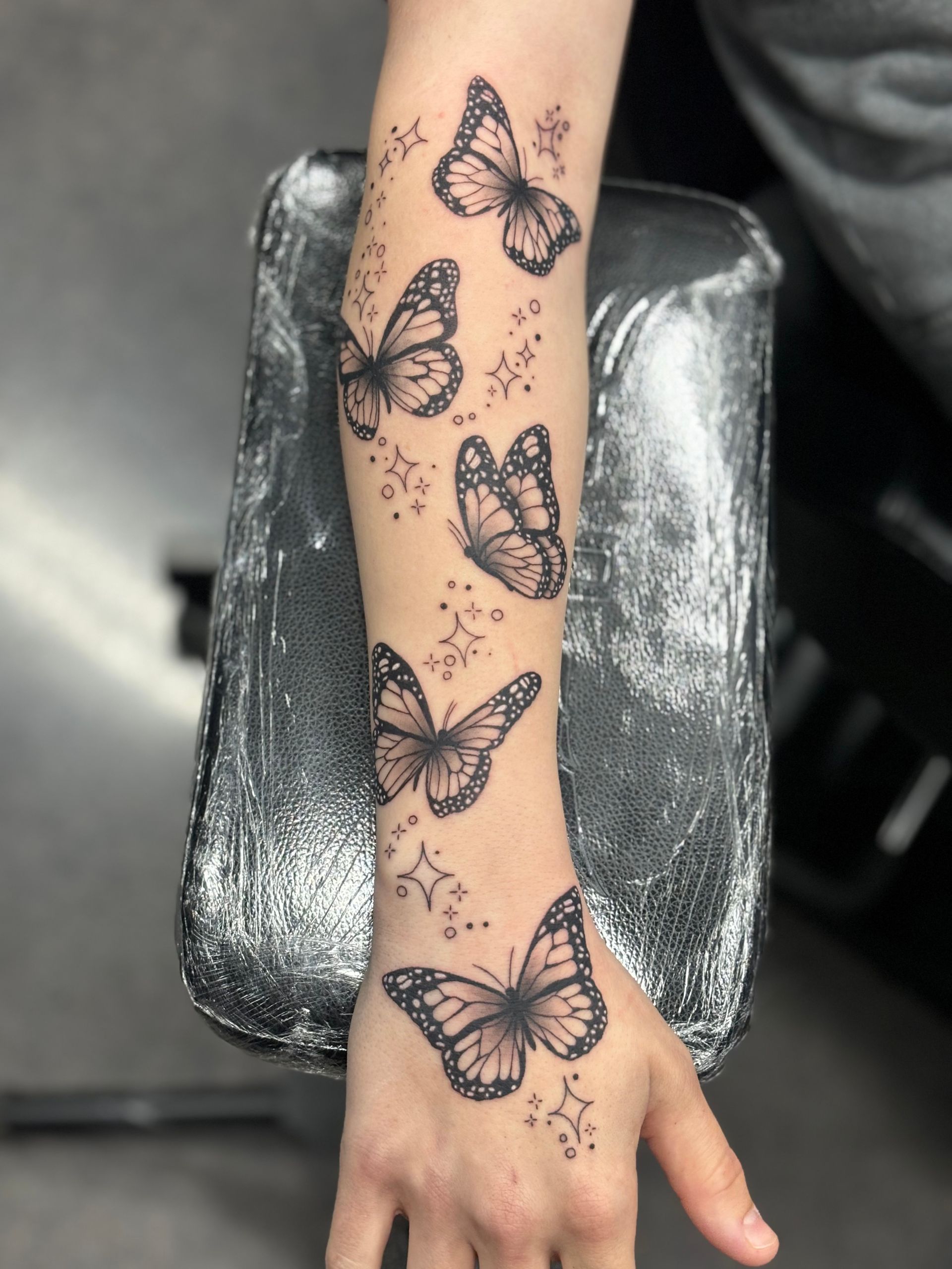 A person has a tattoo of butterflies on their arm