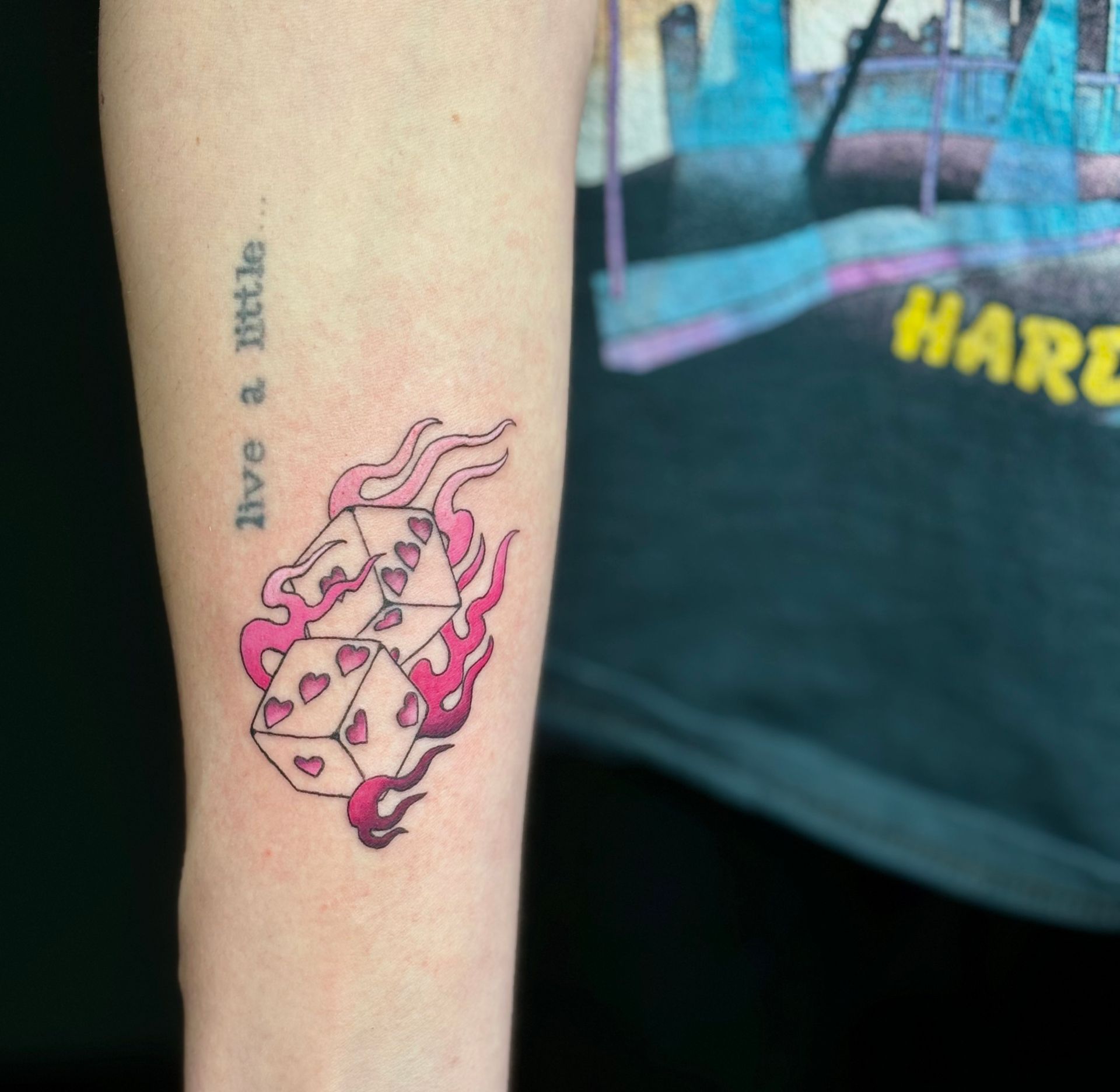 A tattoo on a person 's arm that says live a little