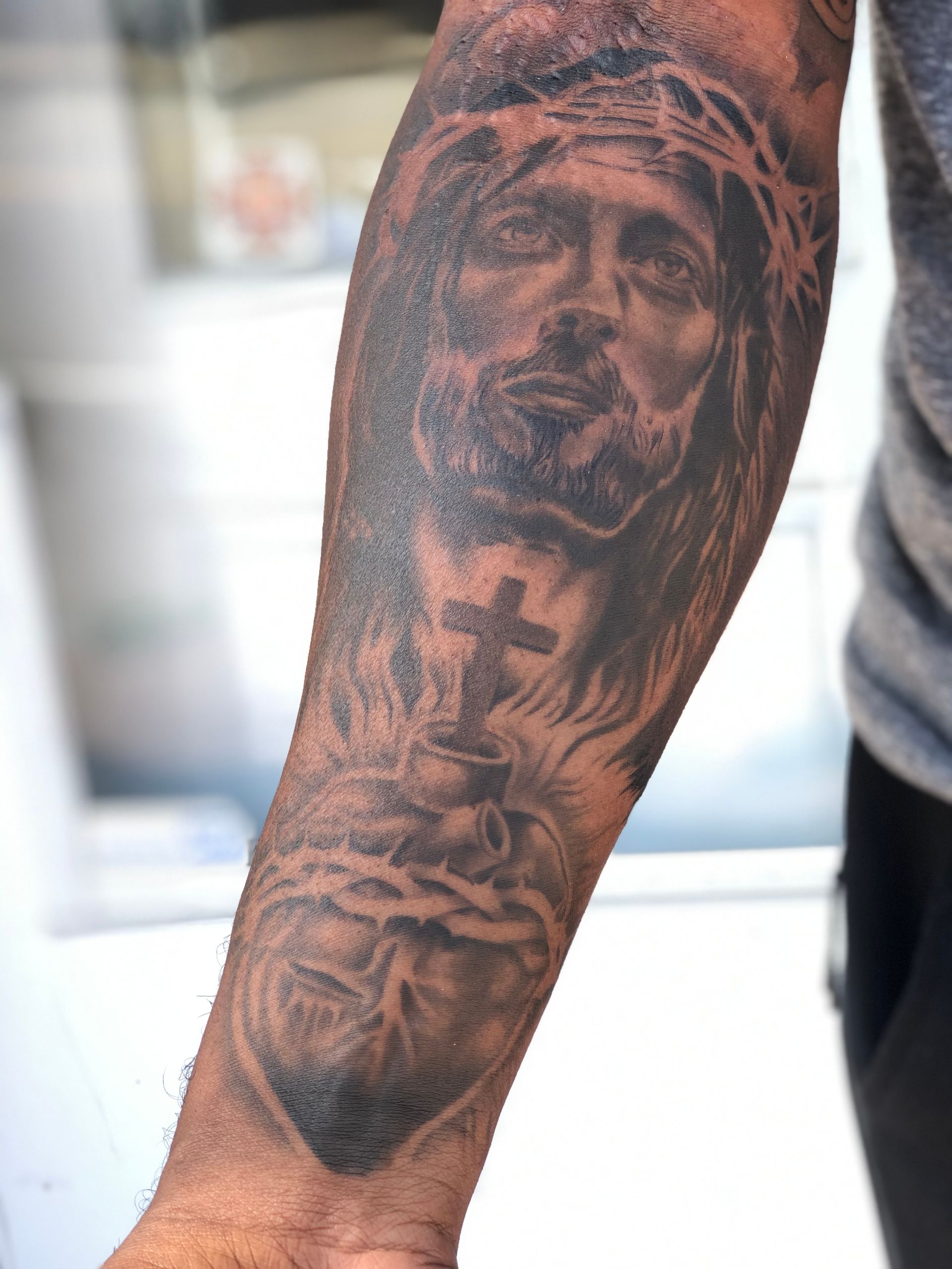 A man has a tattoo of jesus on his arm
