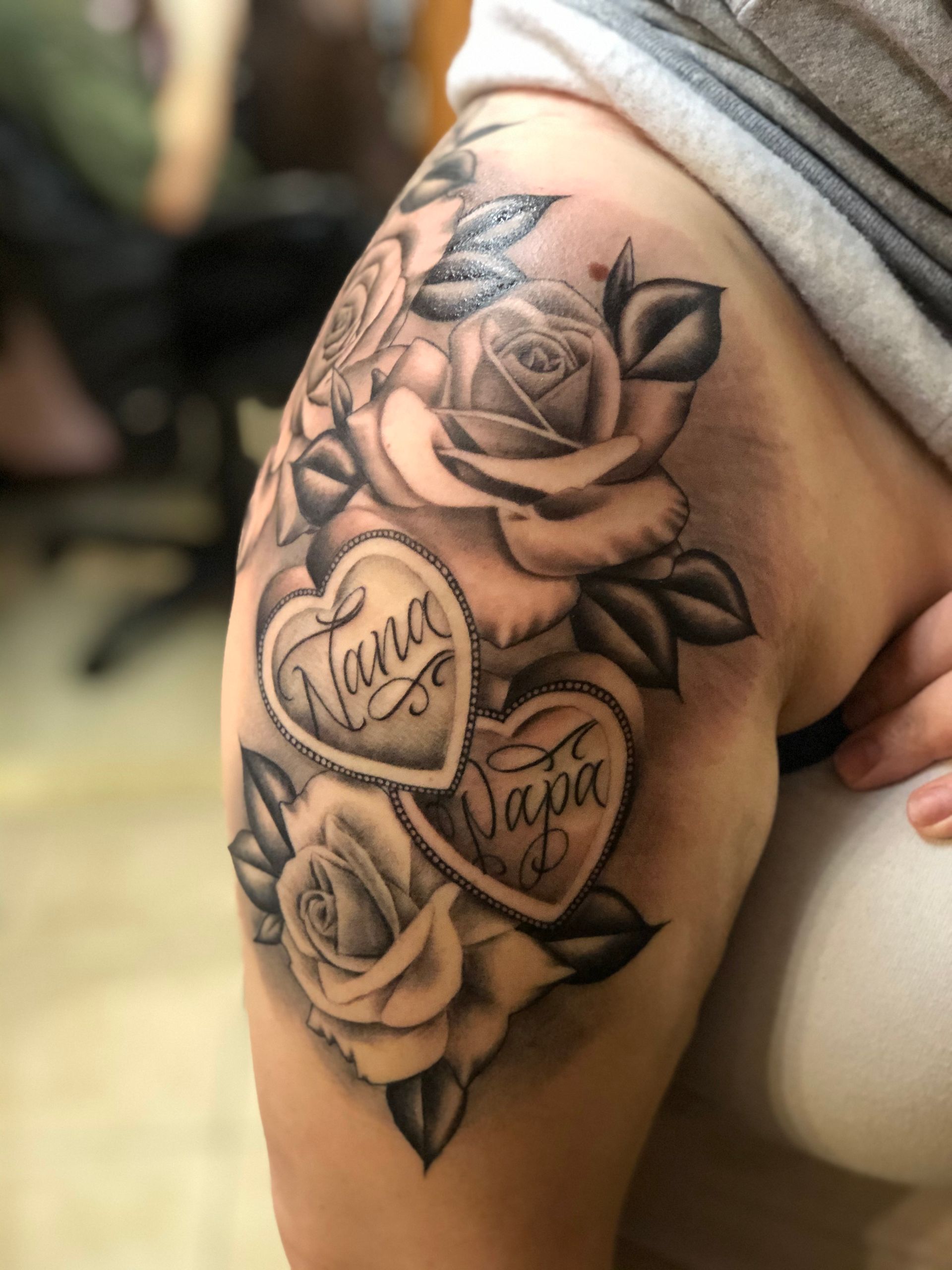 A woman has a tattoo on her shoulder that says nana and papa