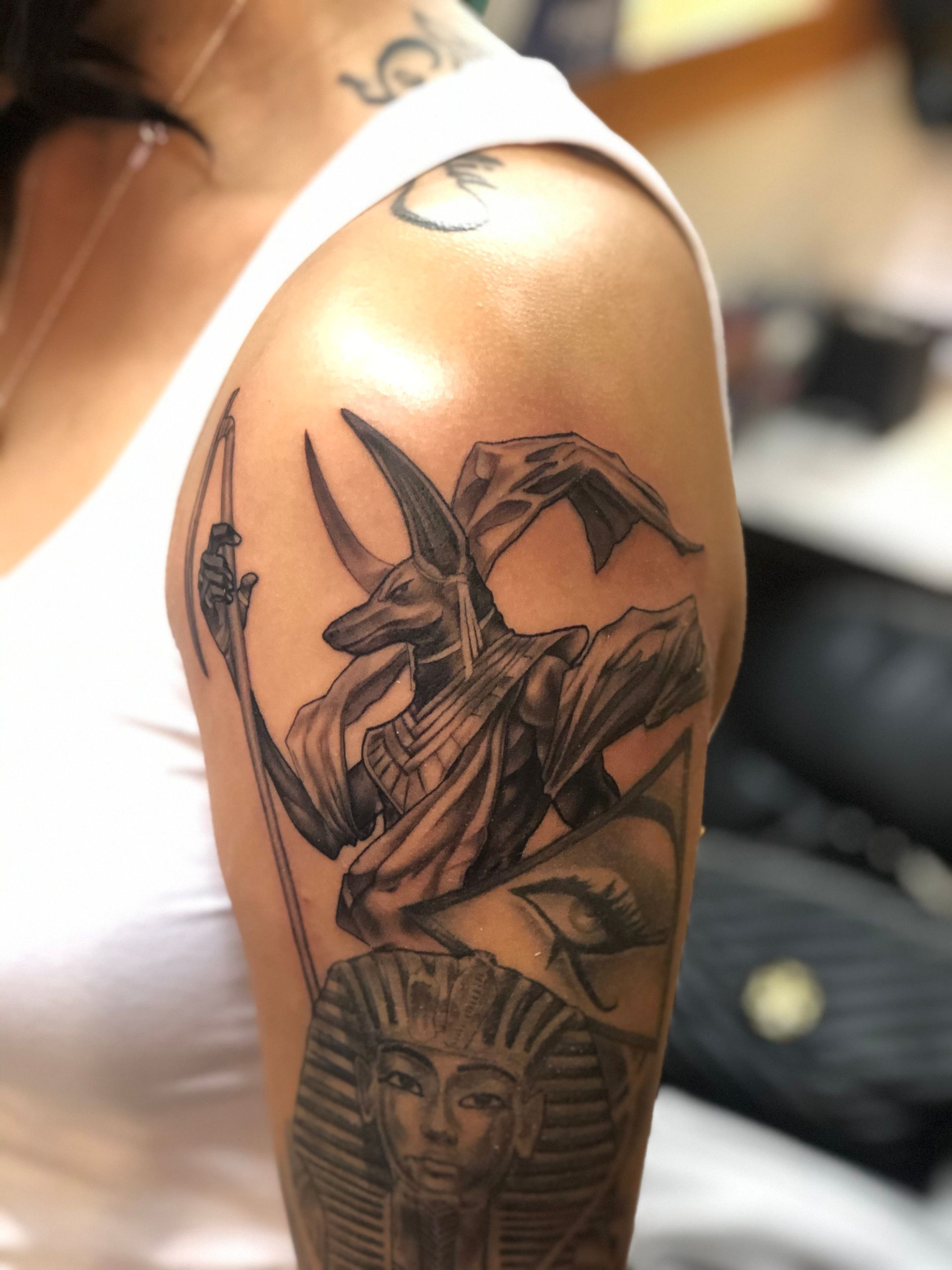 A woman has an anubis tattoo on her arm