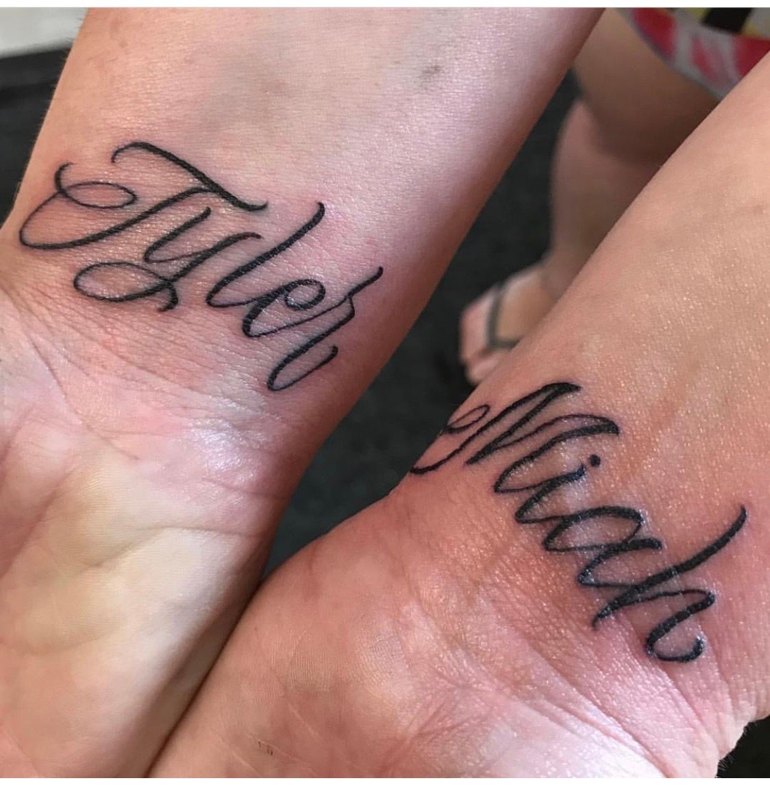 Two wrist tattoos with the names tyler and mike on them