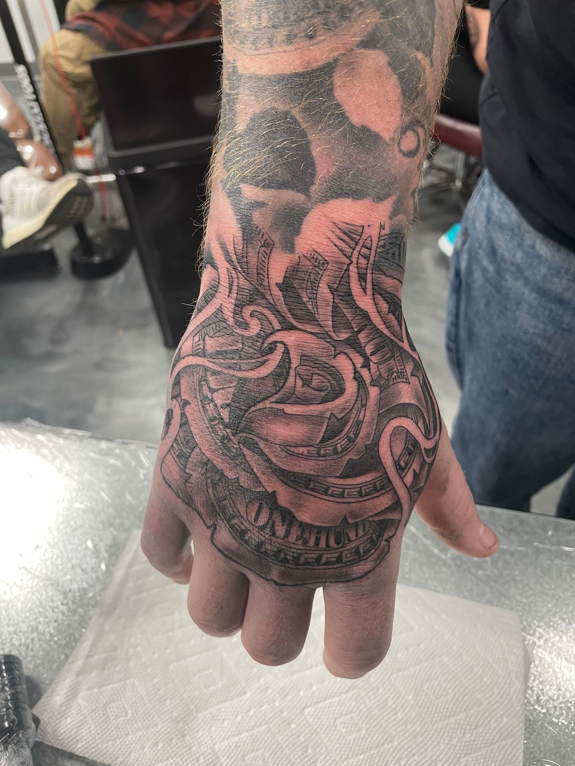 A close up of a person 's hand with a tattoo on it.