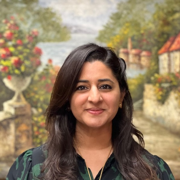 A woman is posing for a picture in front of a painting.
