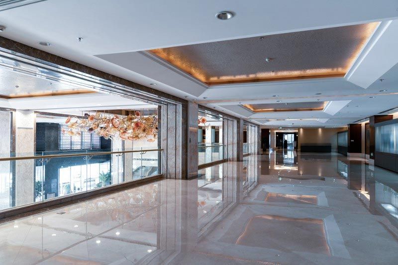 A long hallway in a building with a marble floor and ceiling.