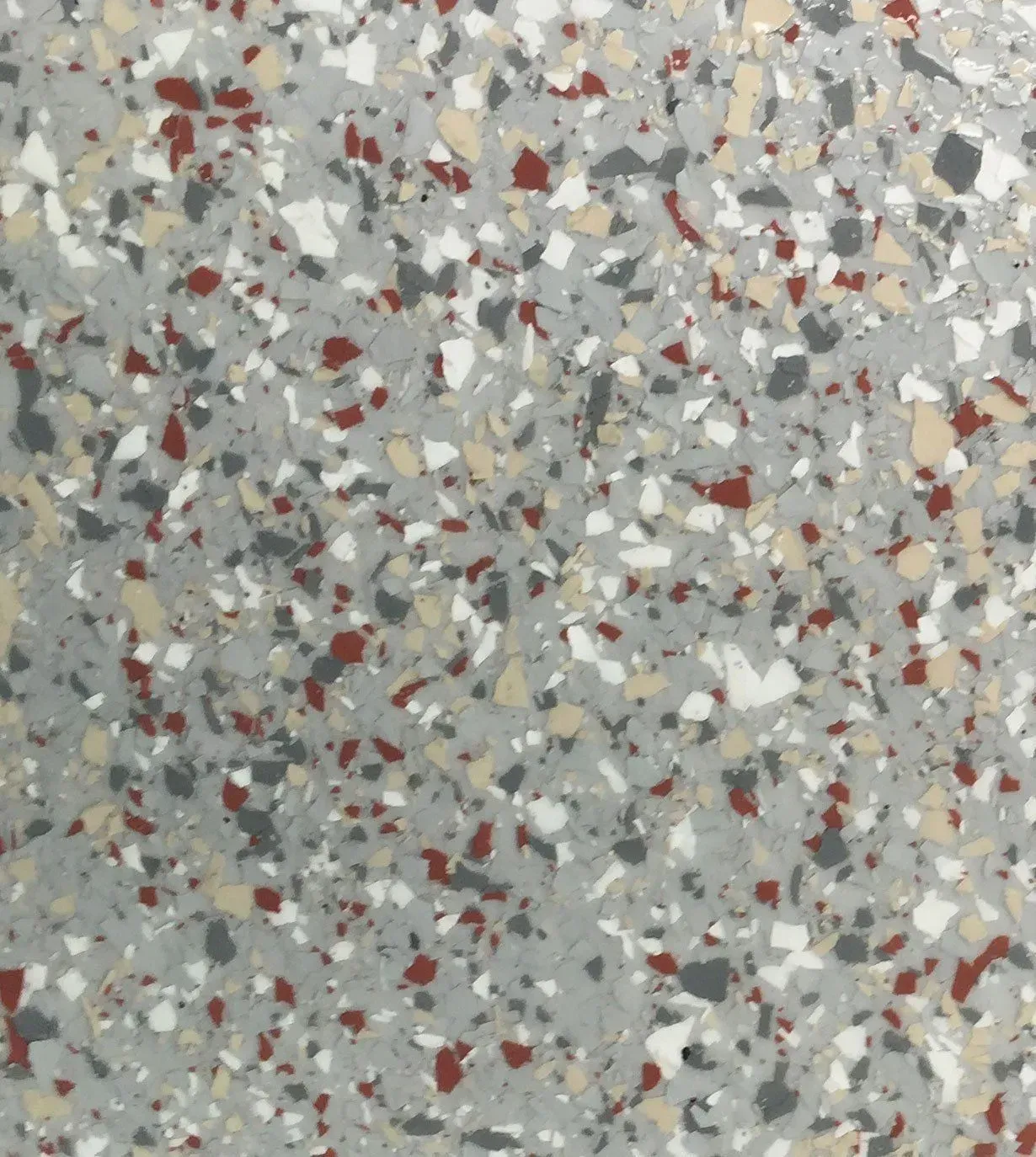 Gray speckled terrazzo surface with scattered red, white, and black chips