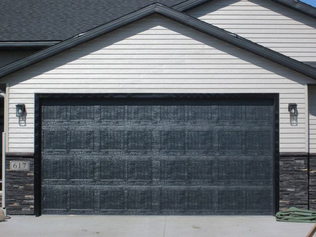 Two-car garage with a dark textured door on a house exterior