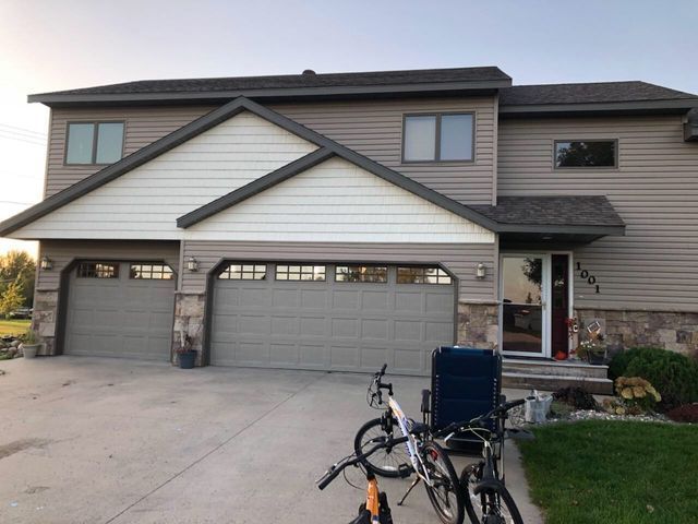 Suburban two-story house with a double garage and a bicycle parked in the driveway.