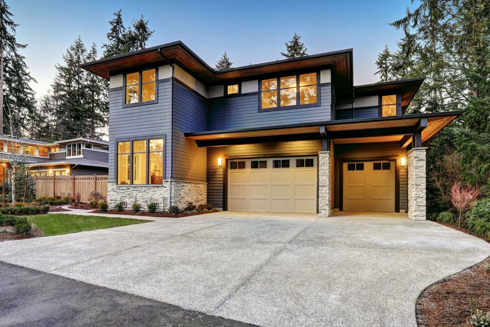Single-story blue house with a brown garage door and front porch under a clear sky
