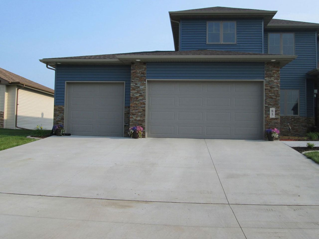 Modern suburban house with two garage doors and a large concrete driveway