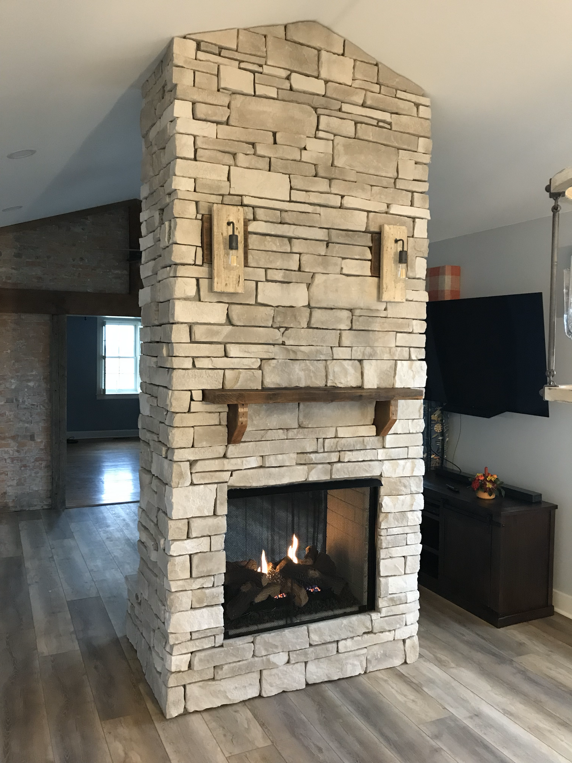 A fireplace in a living room with a brick wall