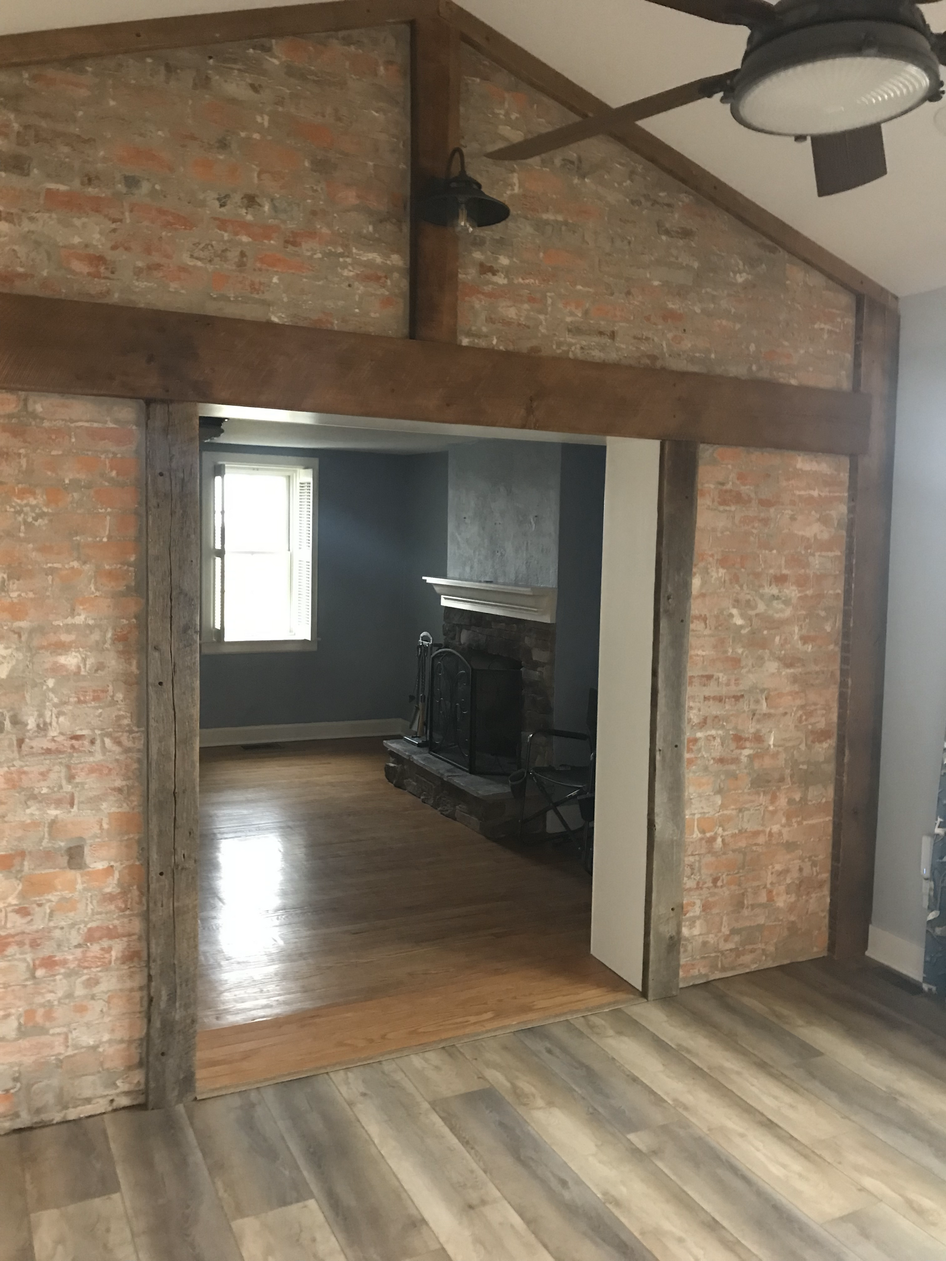 A living room with a fireplace and a ceiling fan.