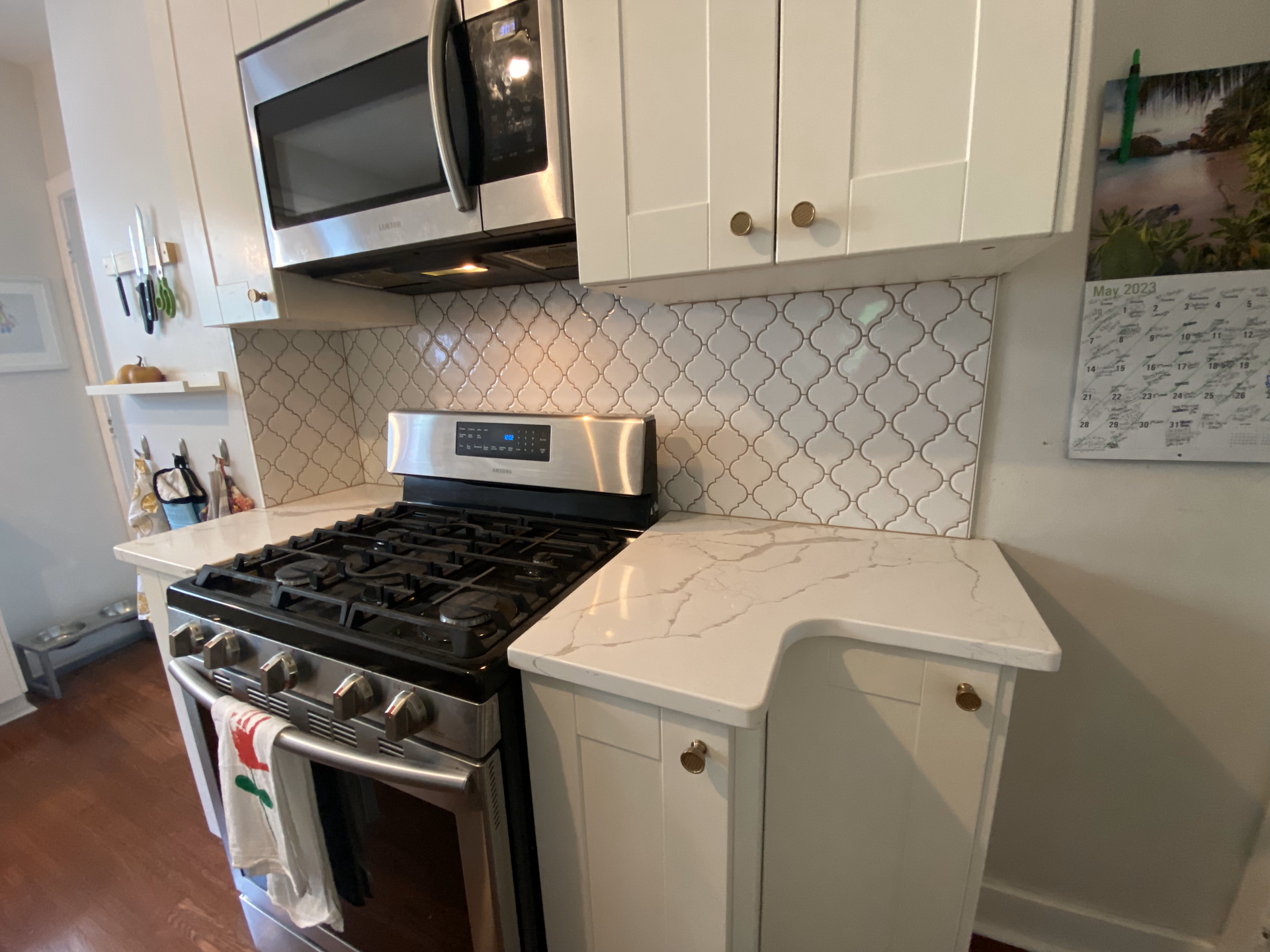 A kitchen with a stove , microwave , and white cabinets.