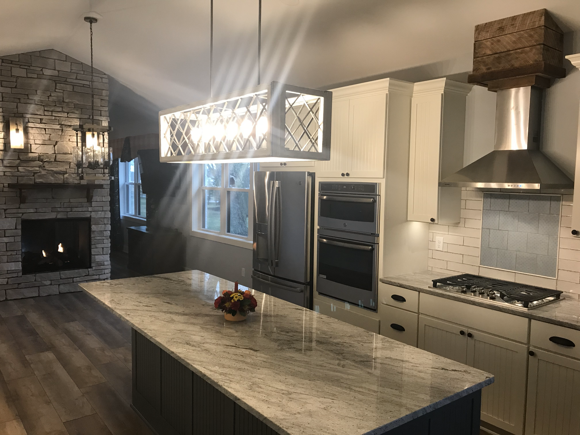 A kitchen with a large island and a fireplace.