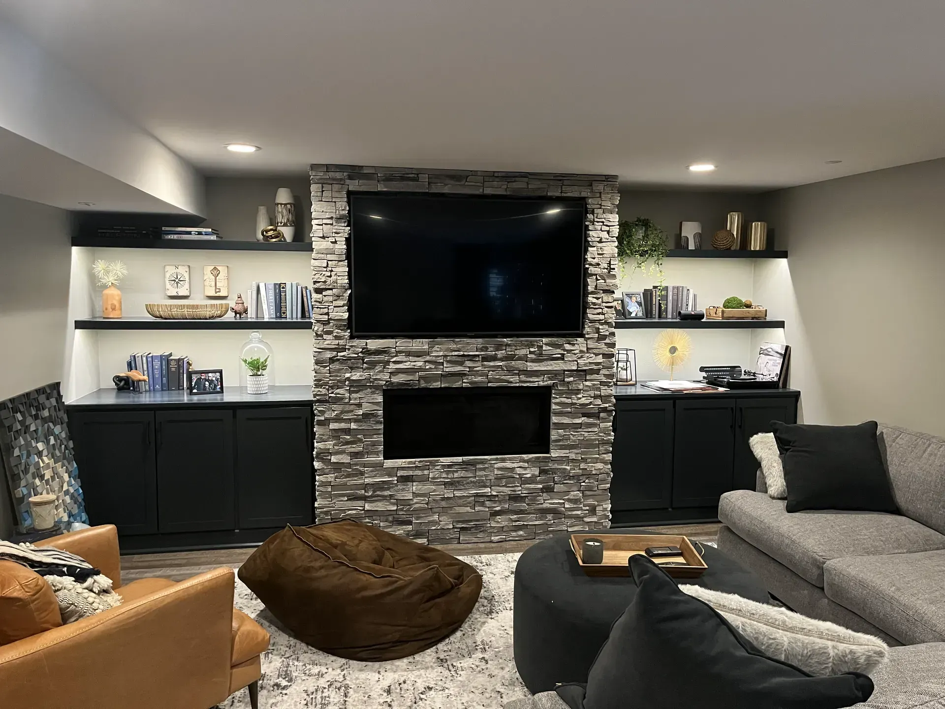 A living room with a couch, television, and fireplace.