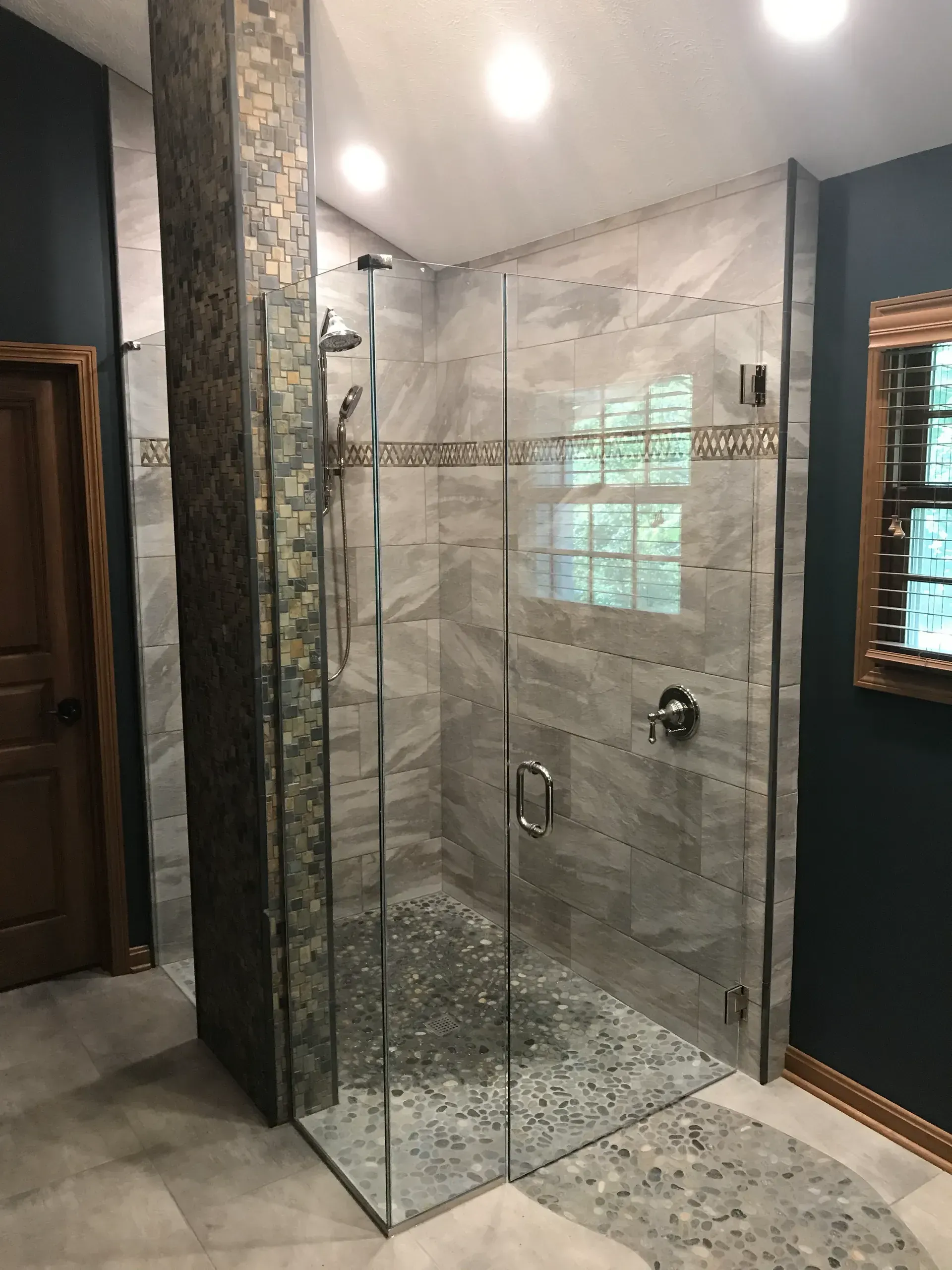 A bathroom with a walk in shower and a mirror.