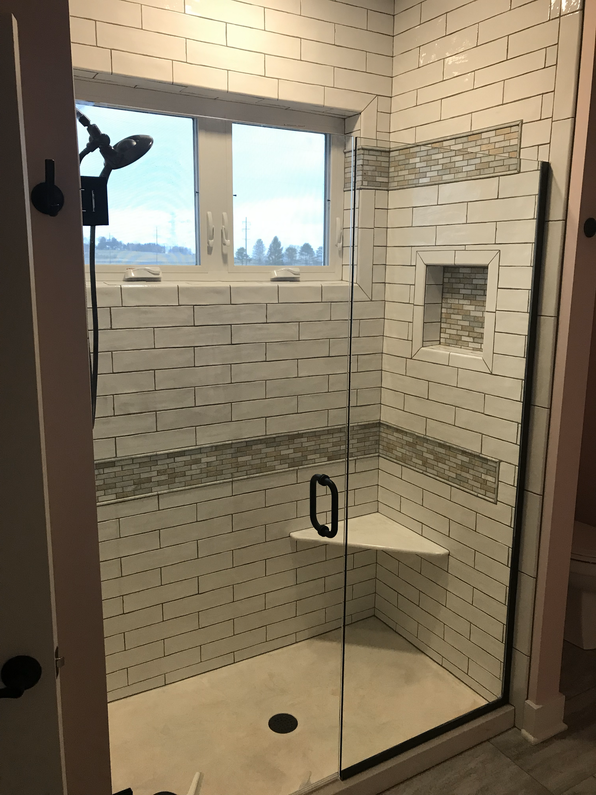 A bathroom with a walk in shower and a window