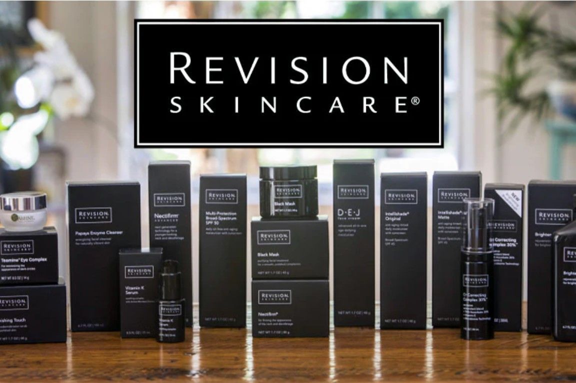 Revision Skincare products are lined up on a wooden table