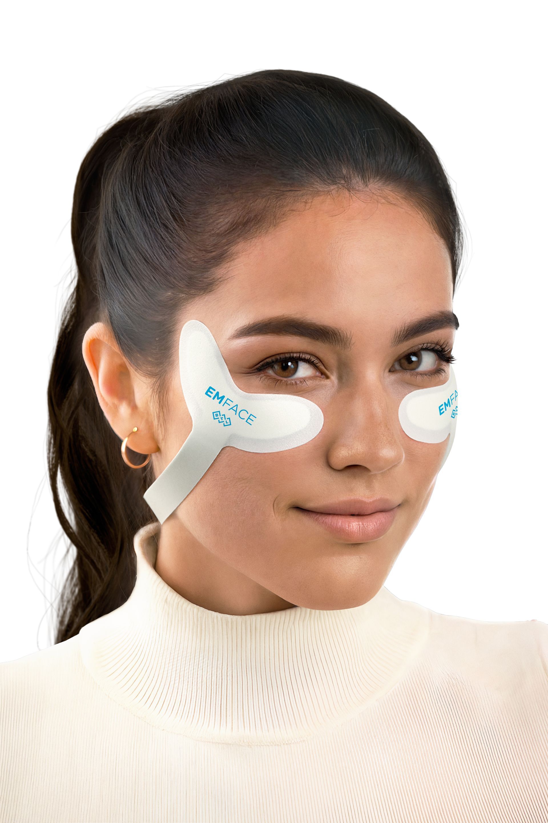 Woman wearing white eye and cheek patches, smiling, looking at the viewer. White background.