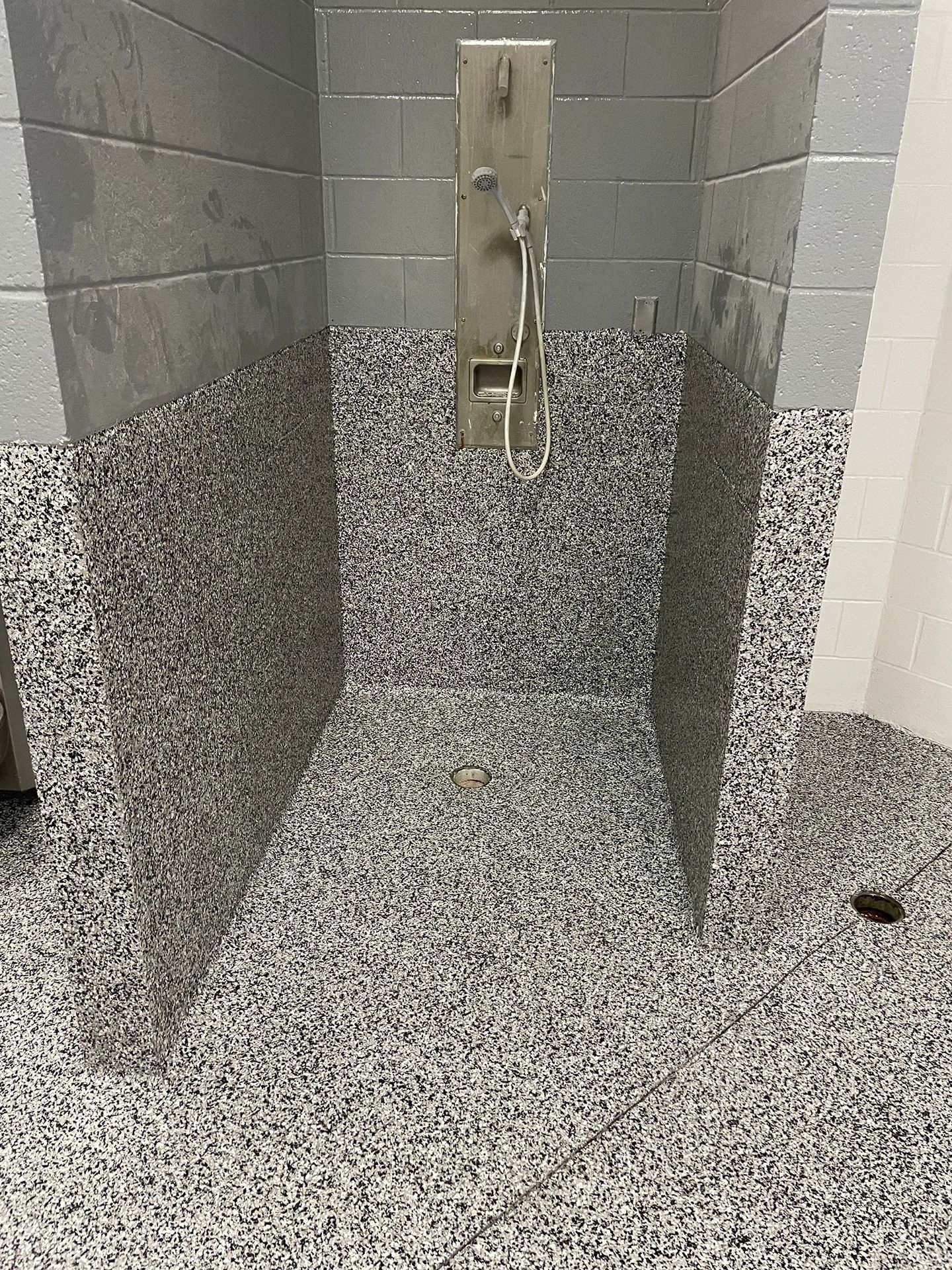 A shower stall with a shower head on the floor