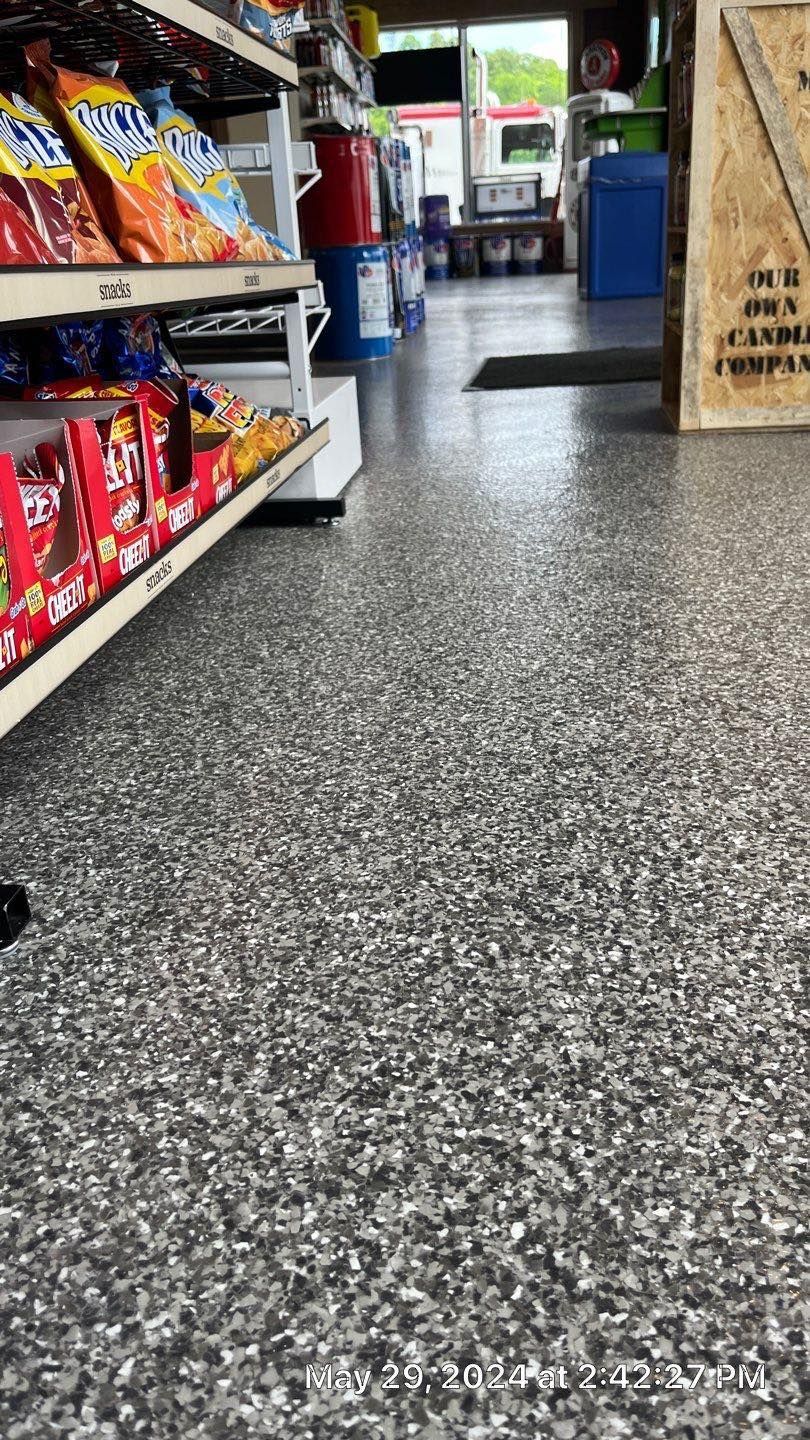 A grocery store with a gray floor and shelves filled with snacks