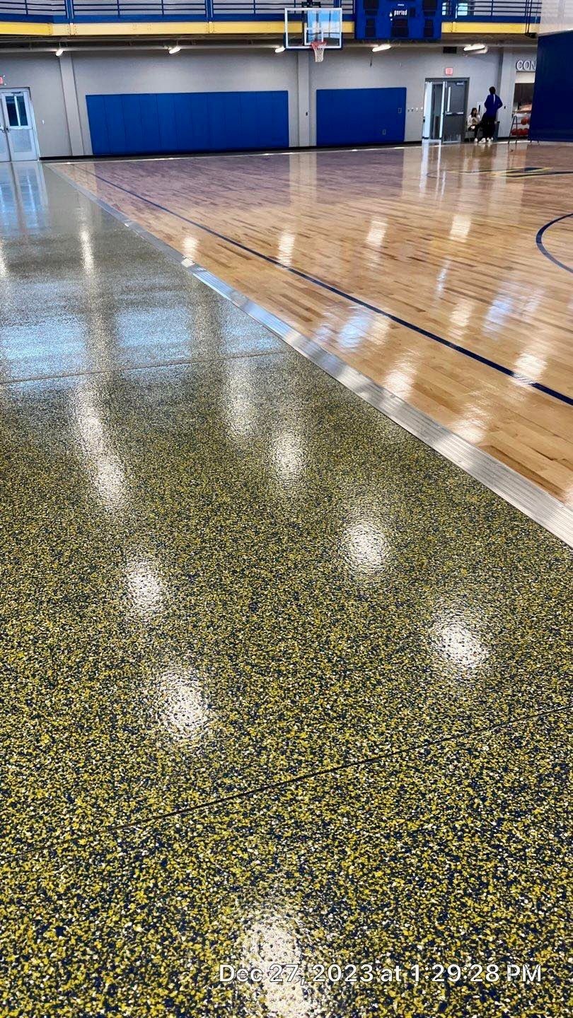 A basketball court with a wooden floor and a basketball hoop