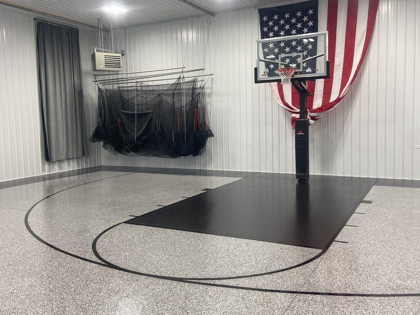 A basketball court in a garage with an American flag on the wall