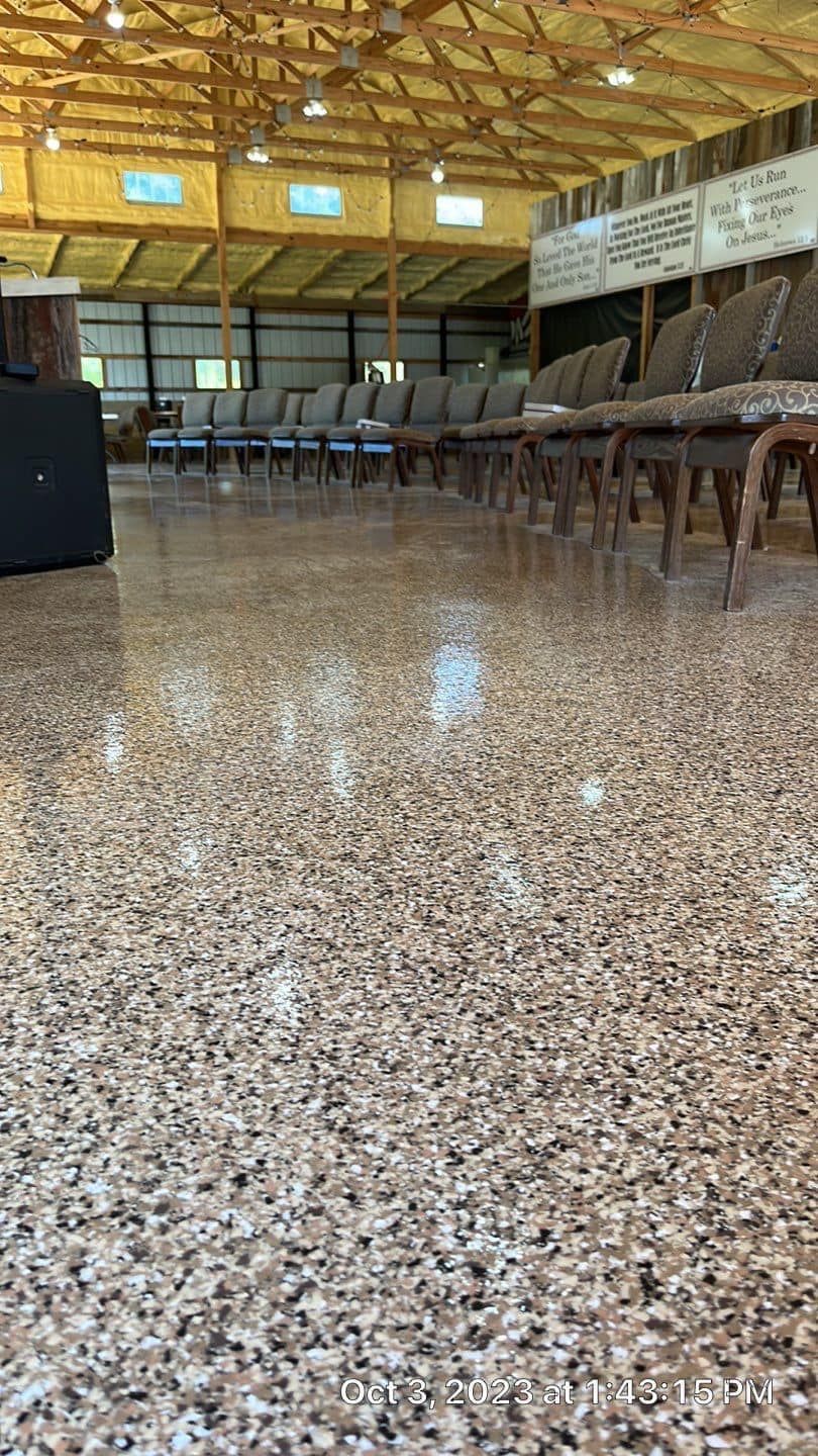 A large room with a concrete floor and rows of chairs