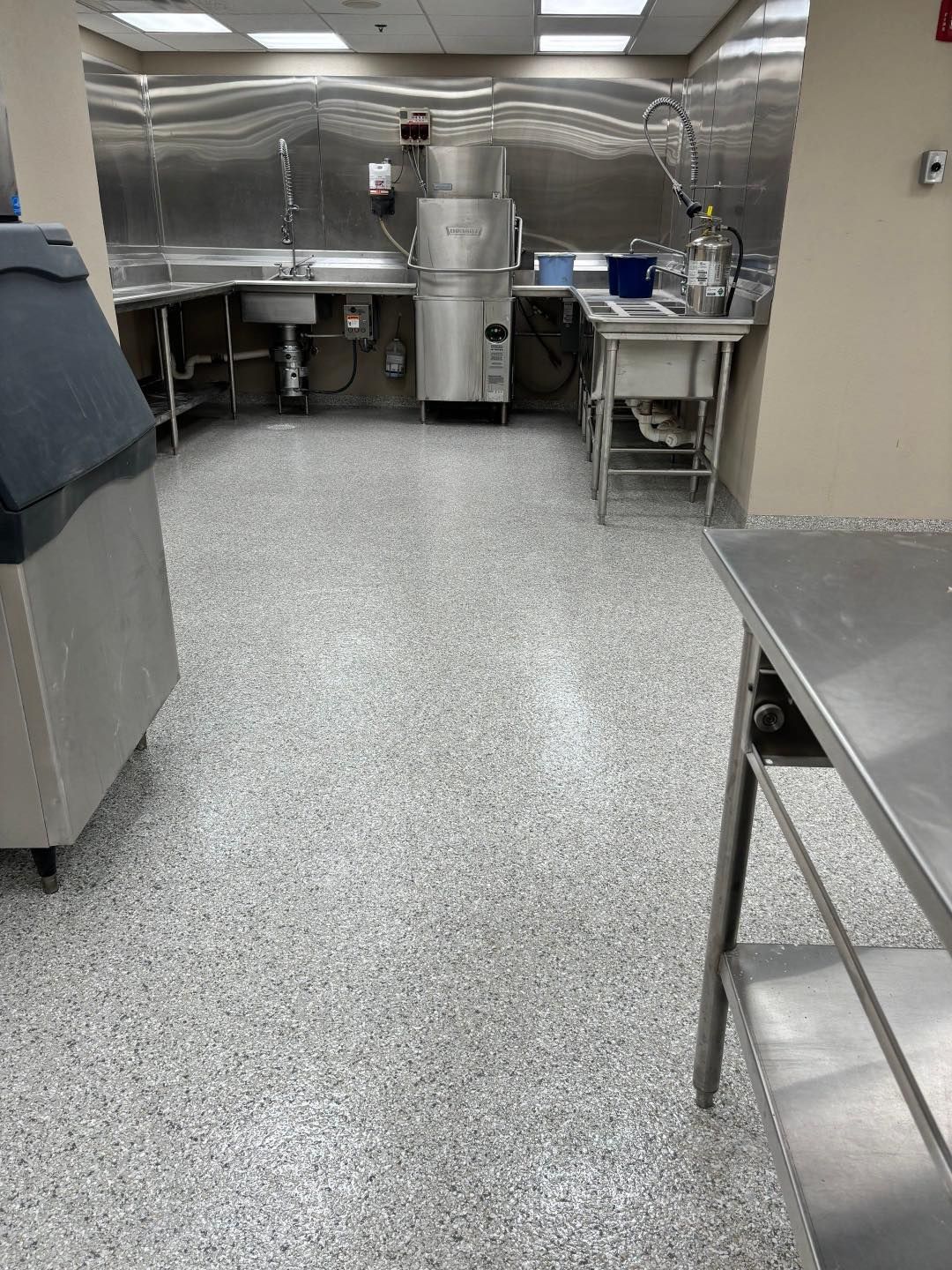 A kitchen with stainless steel appliances and a gray floor