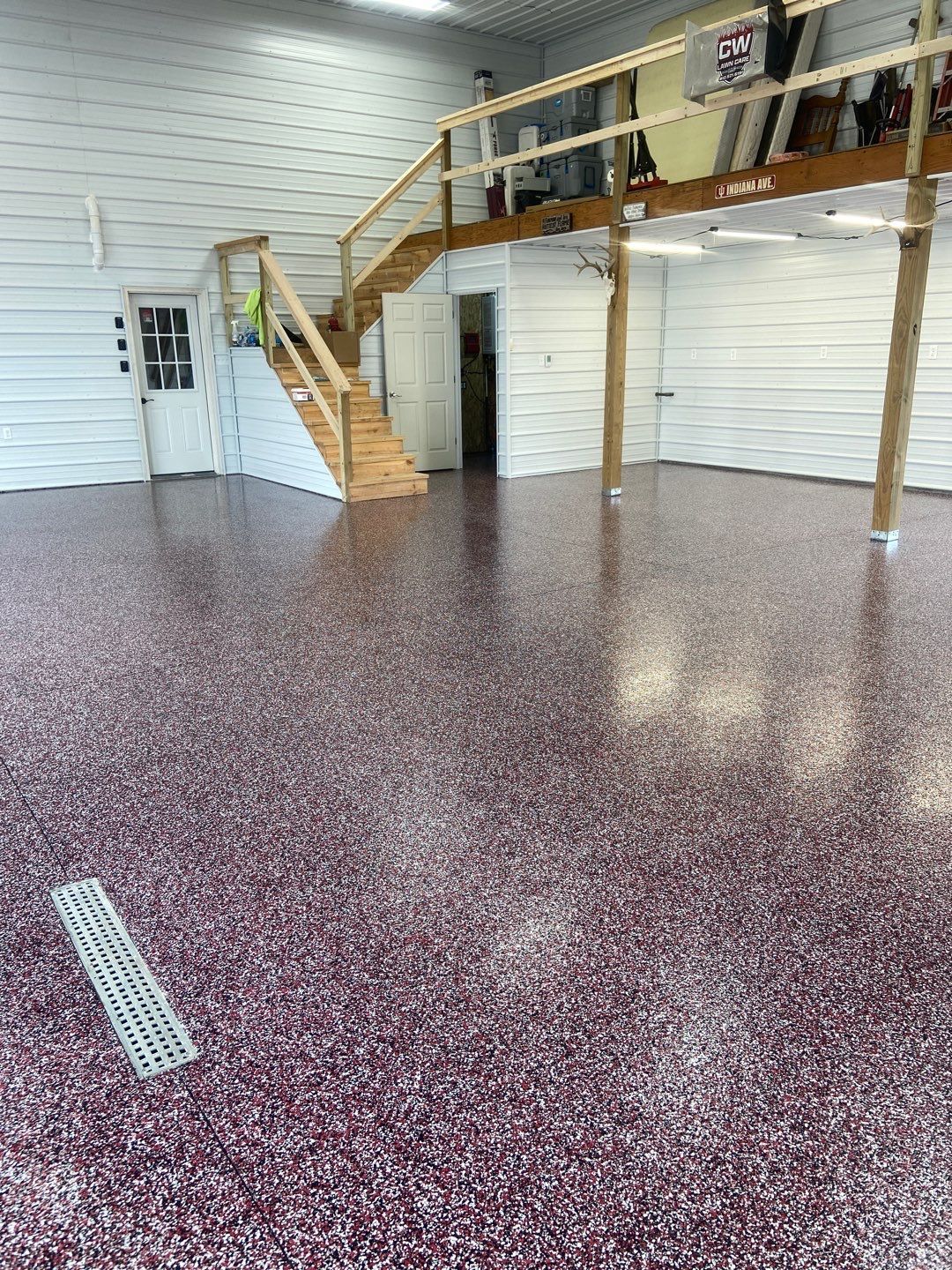 A large garage with a purple floor and stairs