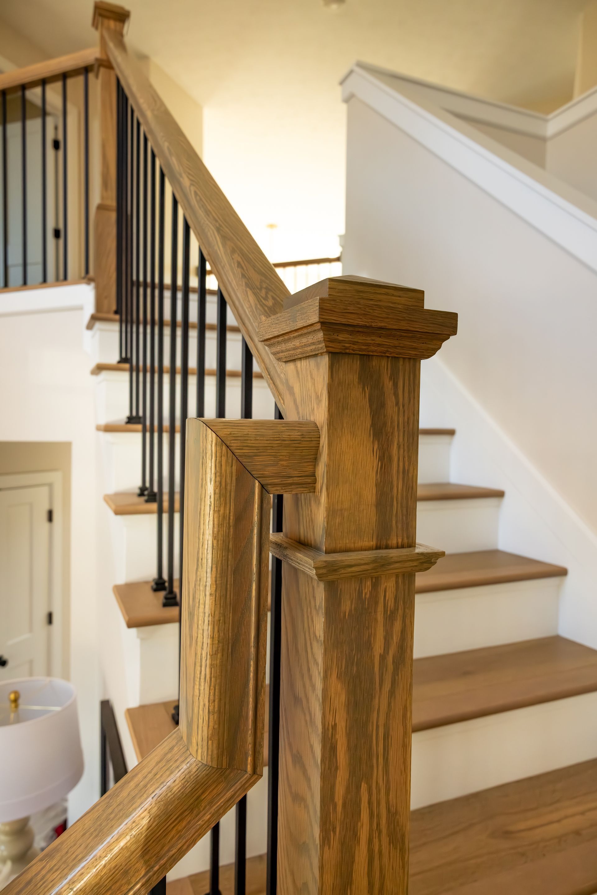 Wooden staircase with white steps and dark railing in a home interior