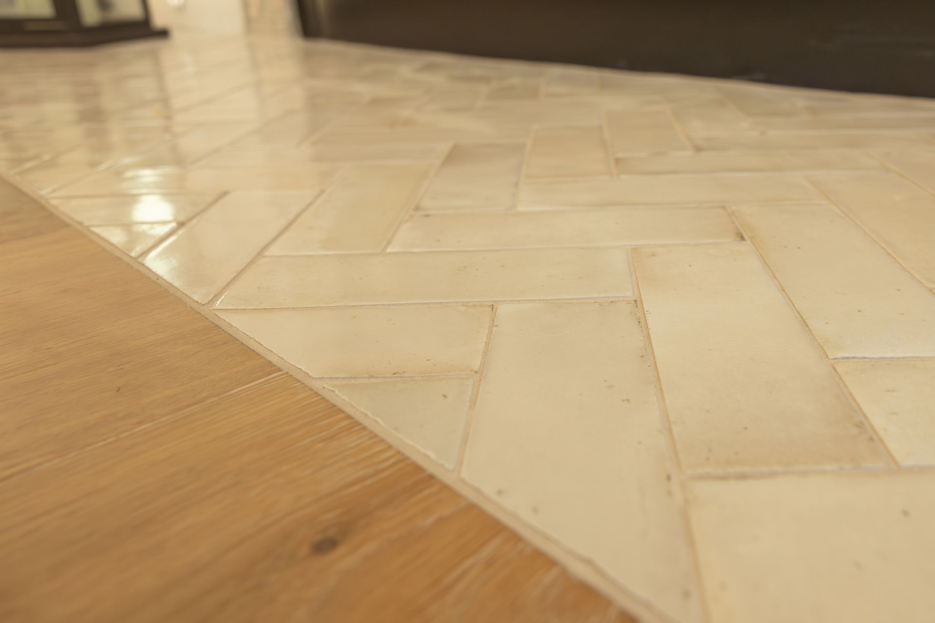 Light wood and cream herringbone flooring with a diagonal seam between sections