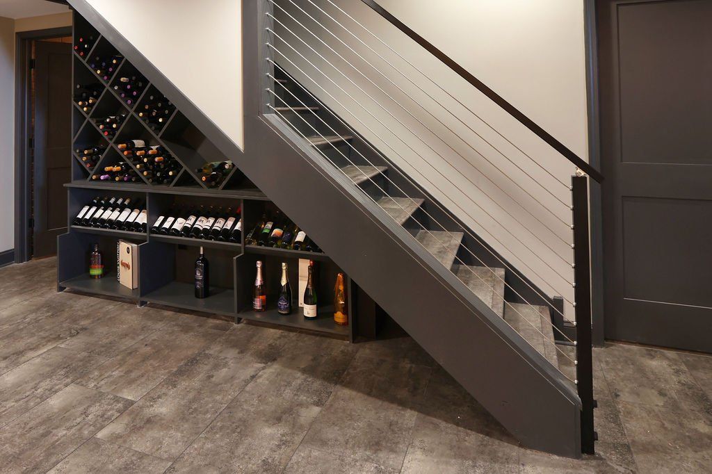 Staircase with cable railings and a wine rack built into the wall, in a modern interior.