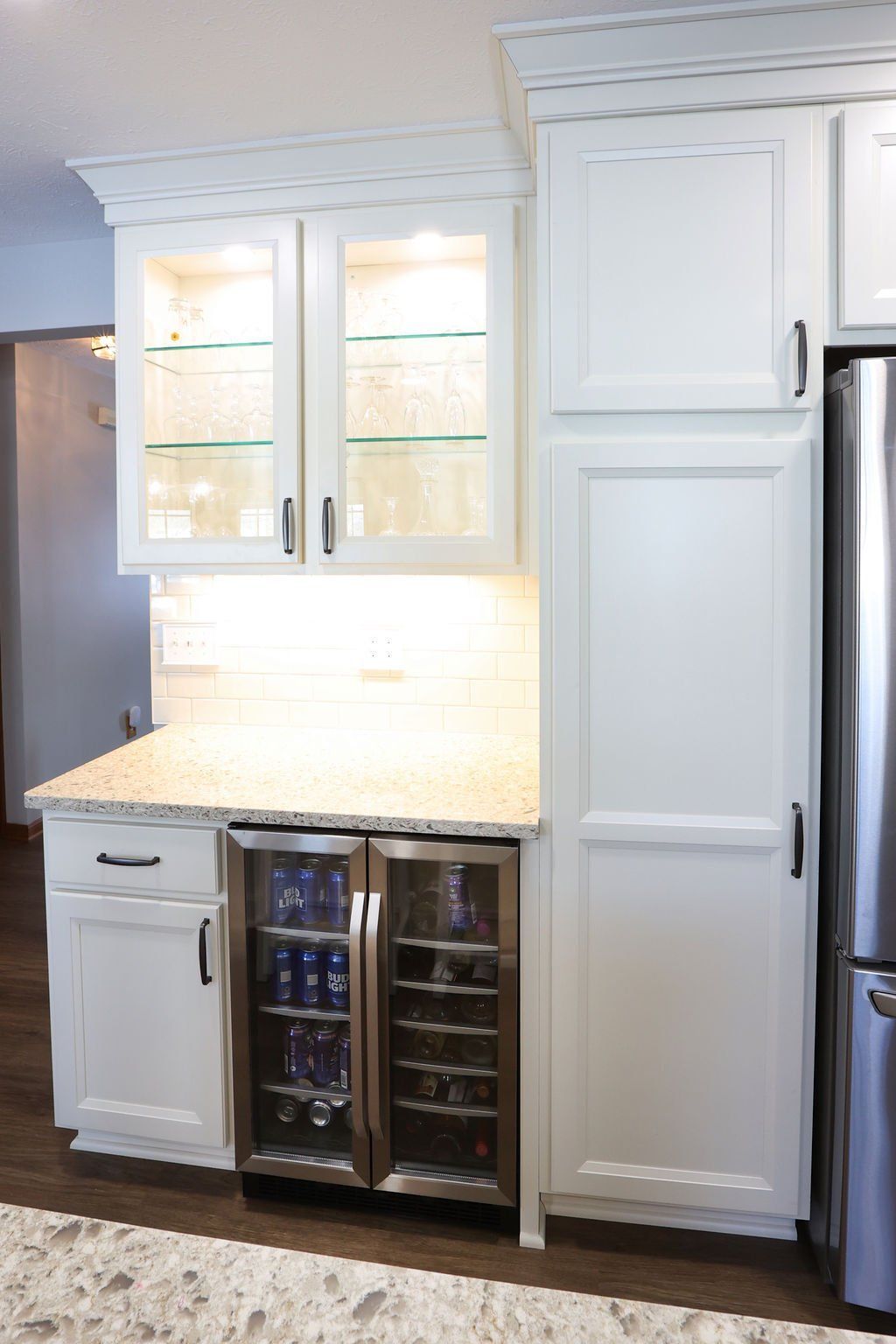 White kitchen cabinets with a built-in wine fridge, a countertop, and glass-front cabinets.