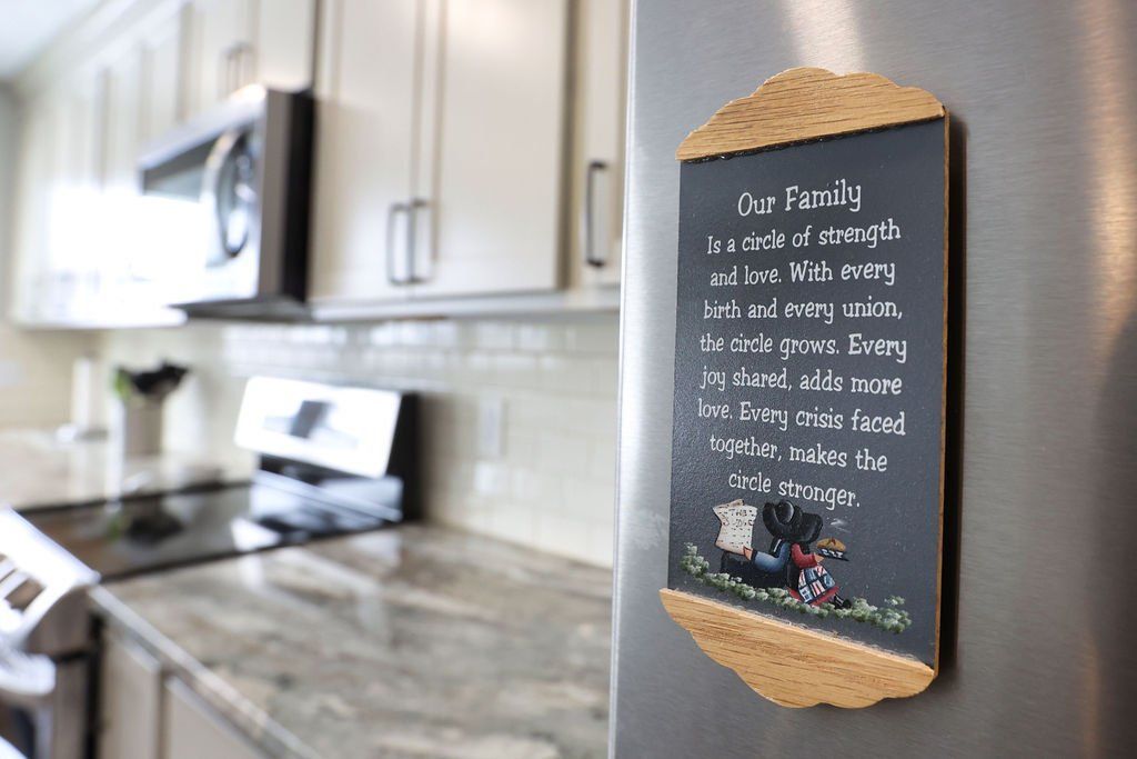 Kitchen with a chalkboard sign on a refrigerator with a quote about family and dogs.