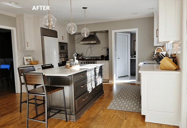 Modern kitchen with dark island, white cabinets, stainless steel appliances, and hardwood floors.